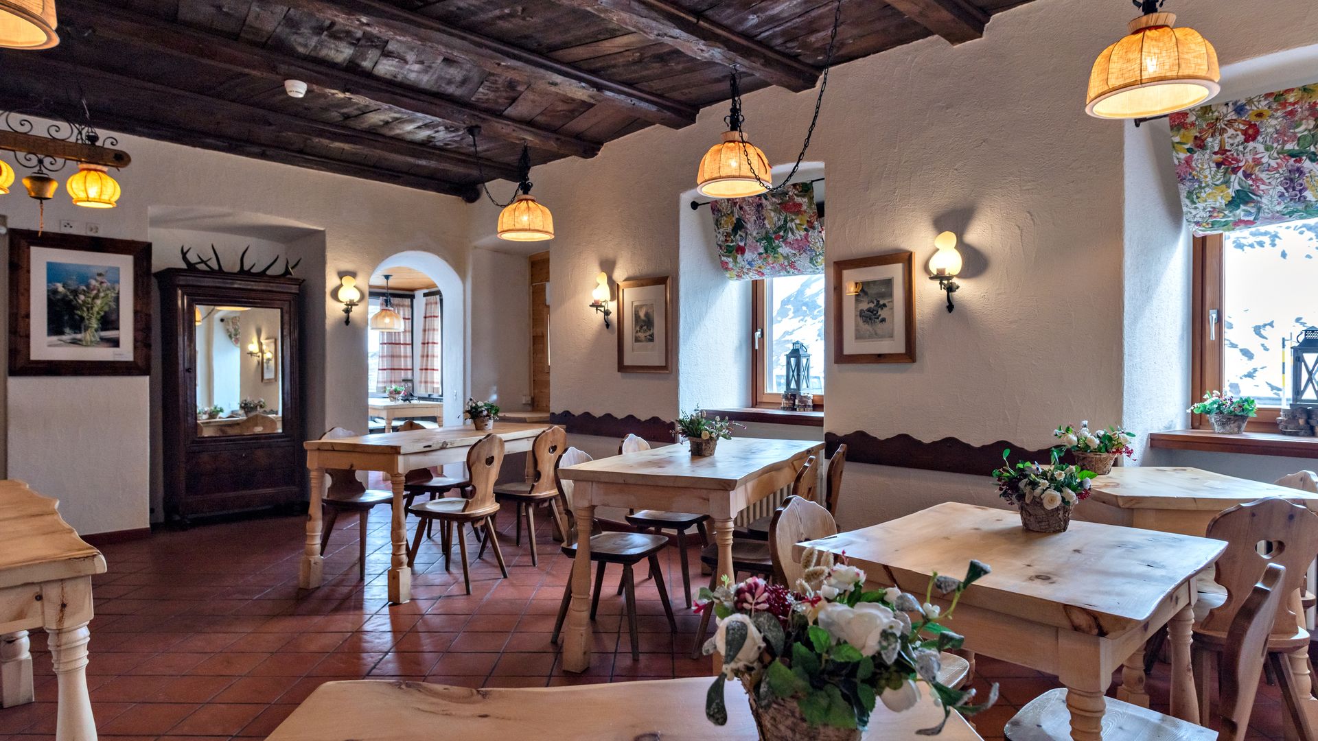 Ein traditionell eingerichtetes Bergrestaurant mit Holzdecken, Holztischen und gemütlicher Atmosphäre im alpinen Stil.