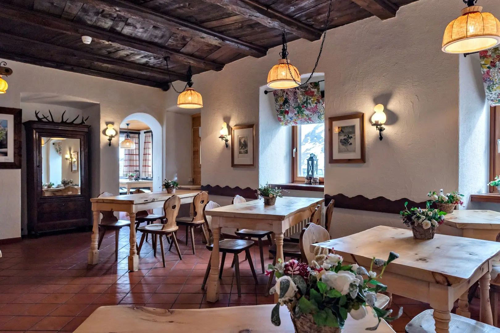 Ein traditionell eingerichtetes Bergrestaurant mit Holzdecken, Holztischen und gemütlicher Atmosphäre im alpinen Stil.