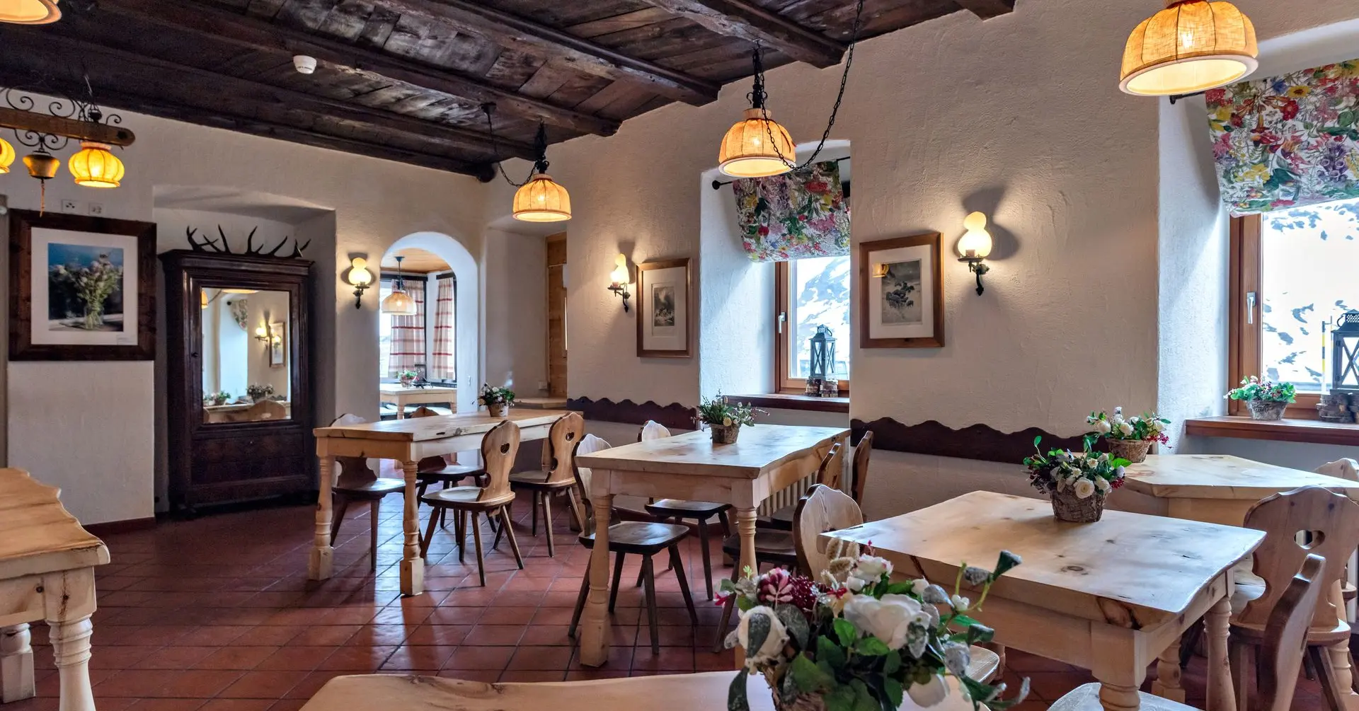 A traditionally furnished mountain restaurant with wooden ceilings, wooden tables and a cosy Alpine-style atmosphere.