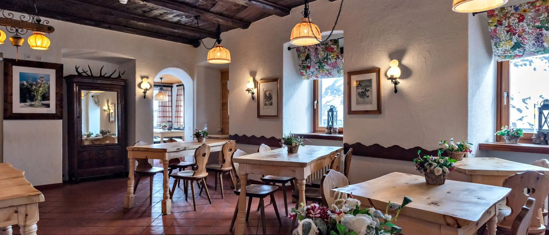 Ein traditionell eingerichtetes Bergrestaurant mit Holzdecken, Holztischen und gemütlicher Atmosphäre im alpinen Stil.