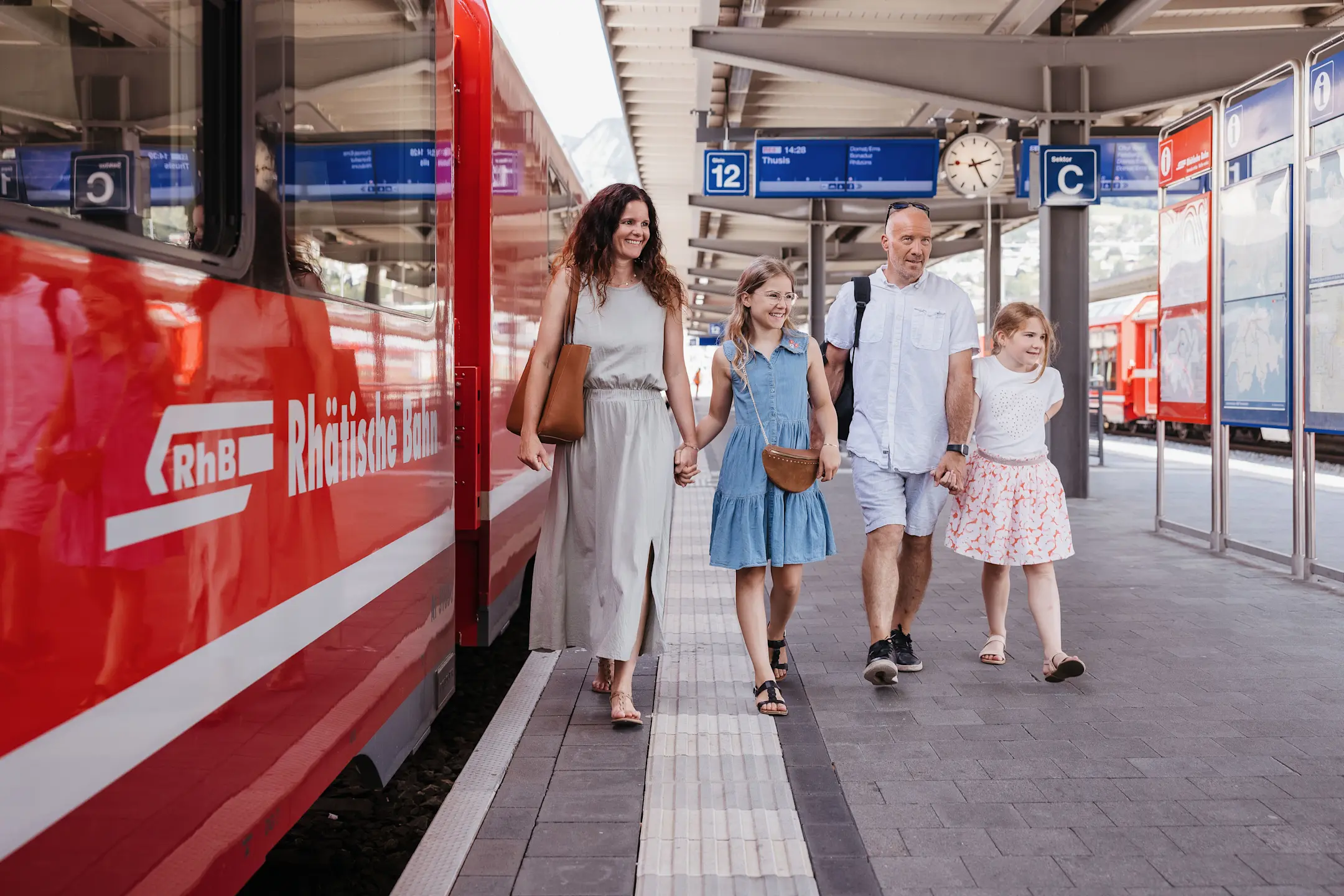 Eine Familie läuft am Perron entlang.