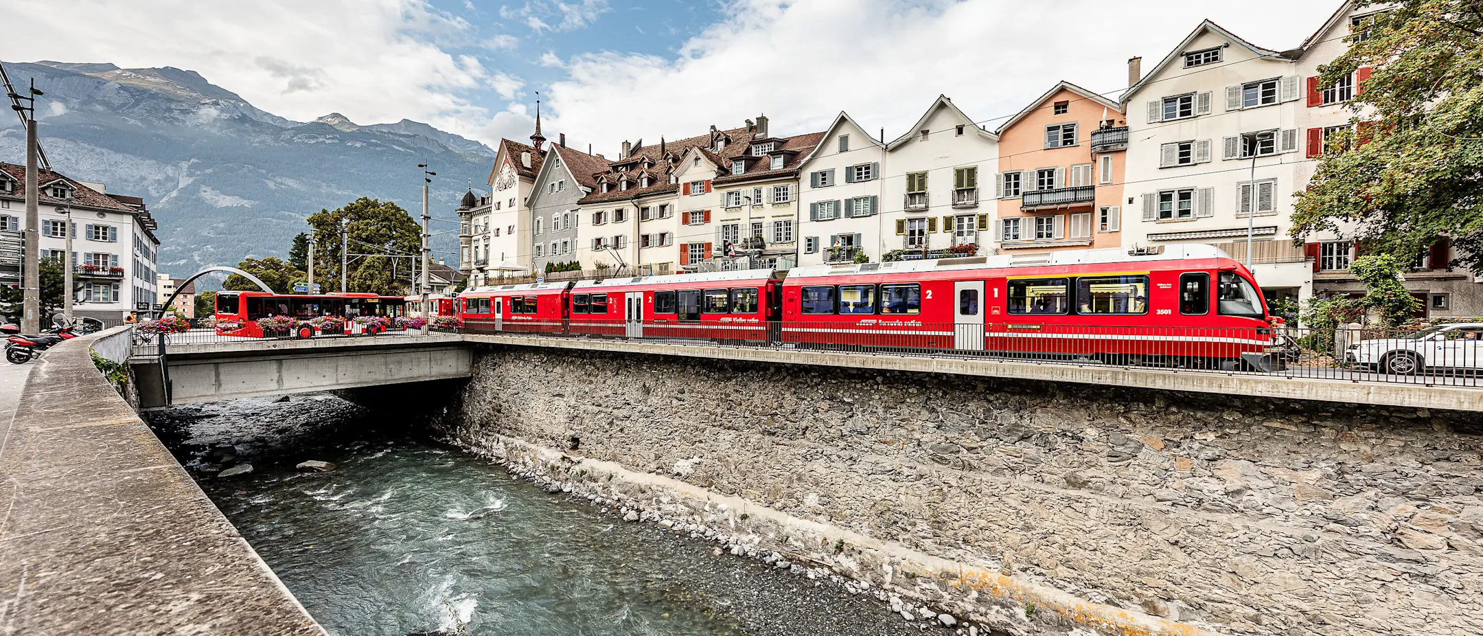 Ein Regionalzug der RhB fährt entlang der Plessur in Chur.