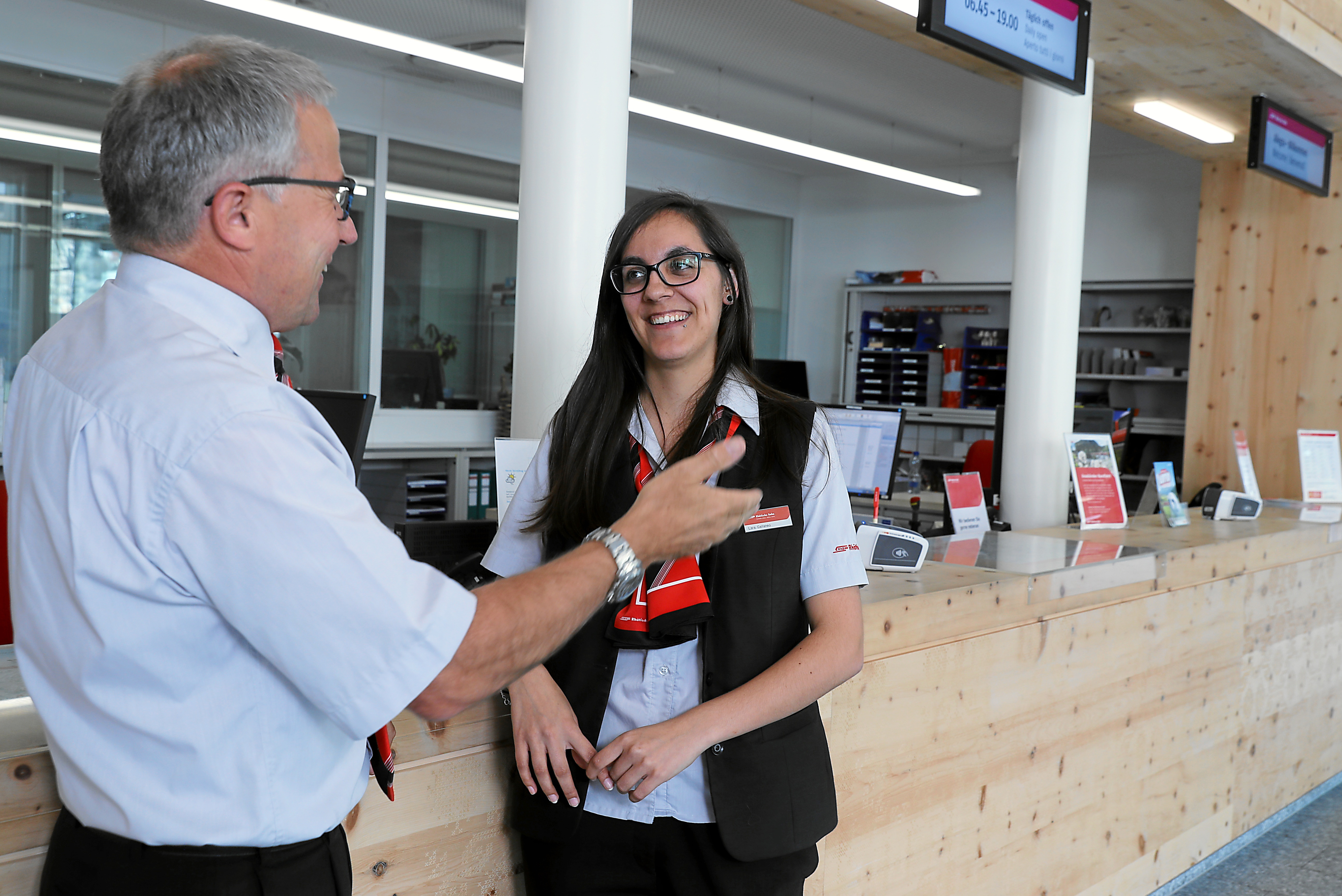Mitarbeiterin und Mitarbeiter im Dialog vor PC im Railservice