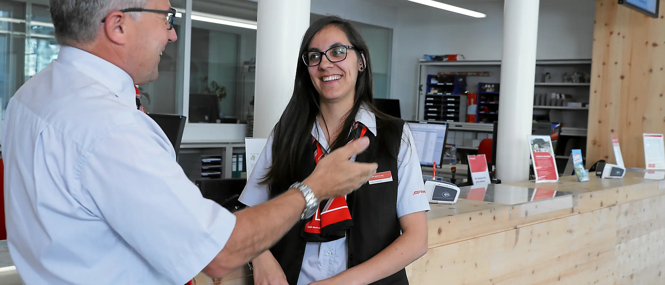 Mitarbeiterin und Mitarbeiter im Dialog vor PC im Railservice