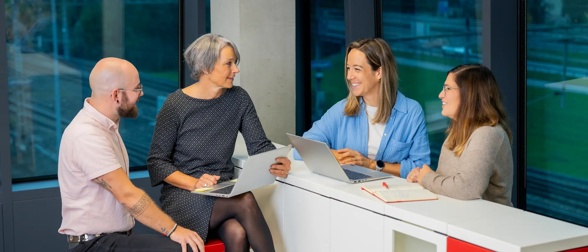 Vier Mitarbeitenden an einer Besprechung