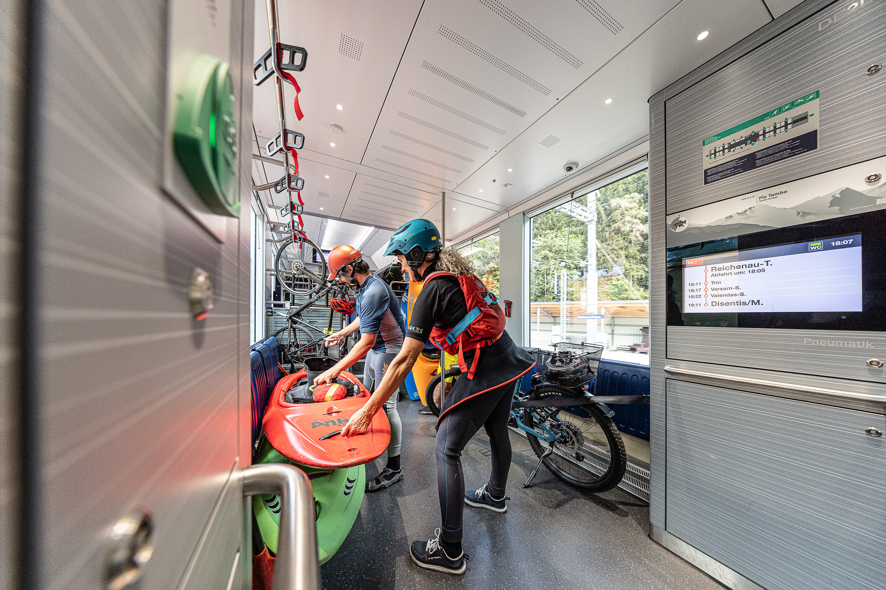 Zwei Personen sichern im Capricorn-Triebzug ihre Kanus für den Transport
