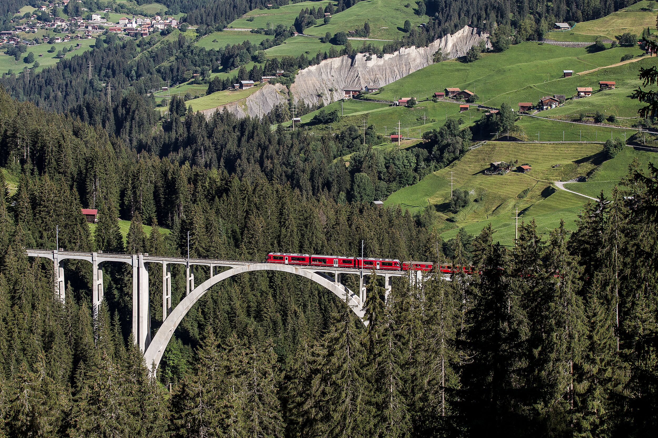 Ein Regionalzug der RhB fährt auf der Arosalinie über den Landwieserviadukt.
