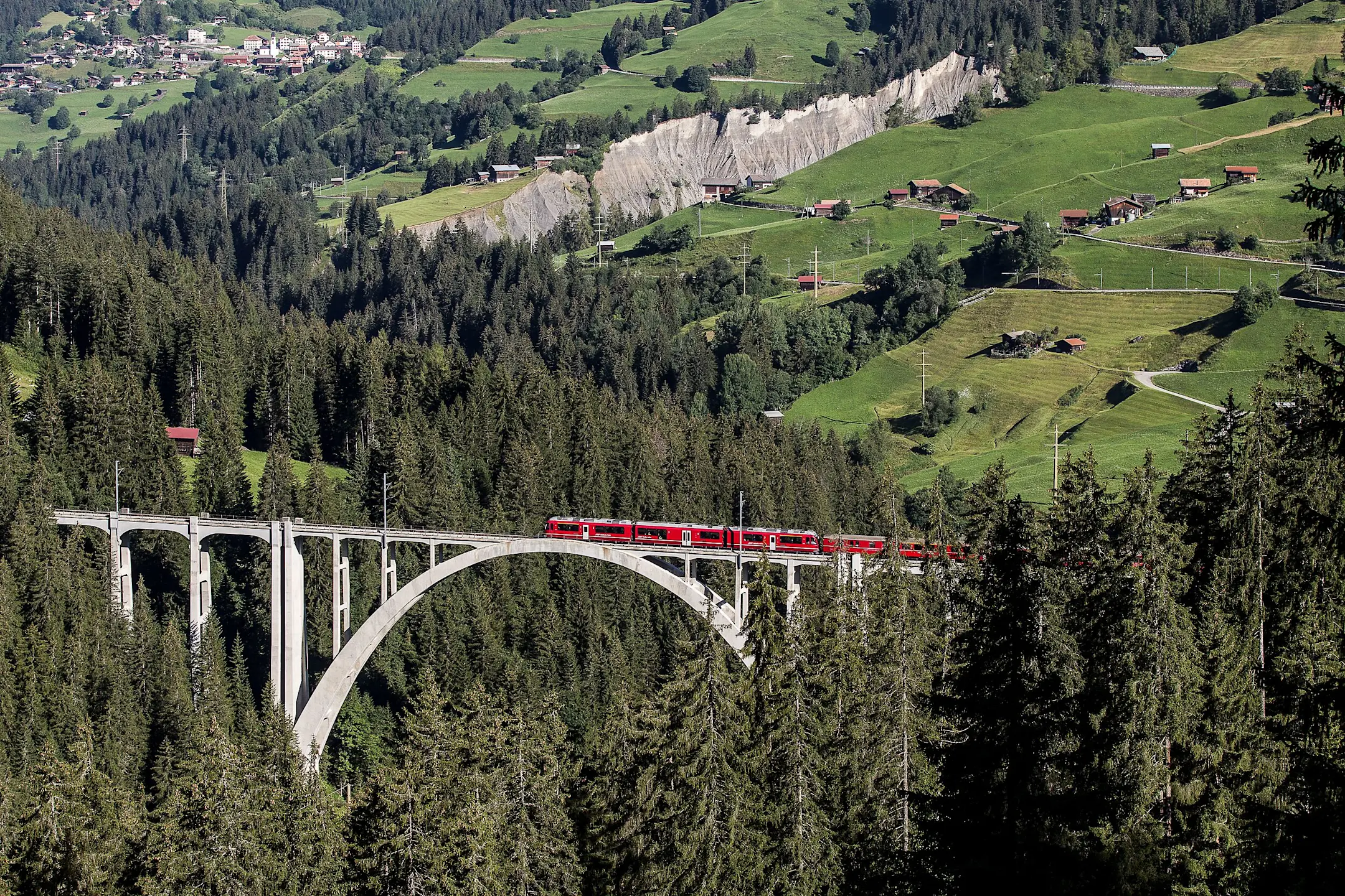 Ein Regionalzug der RhB fährt auf der Arosalinie über den Landwieserviadukt.