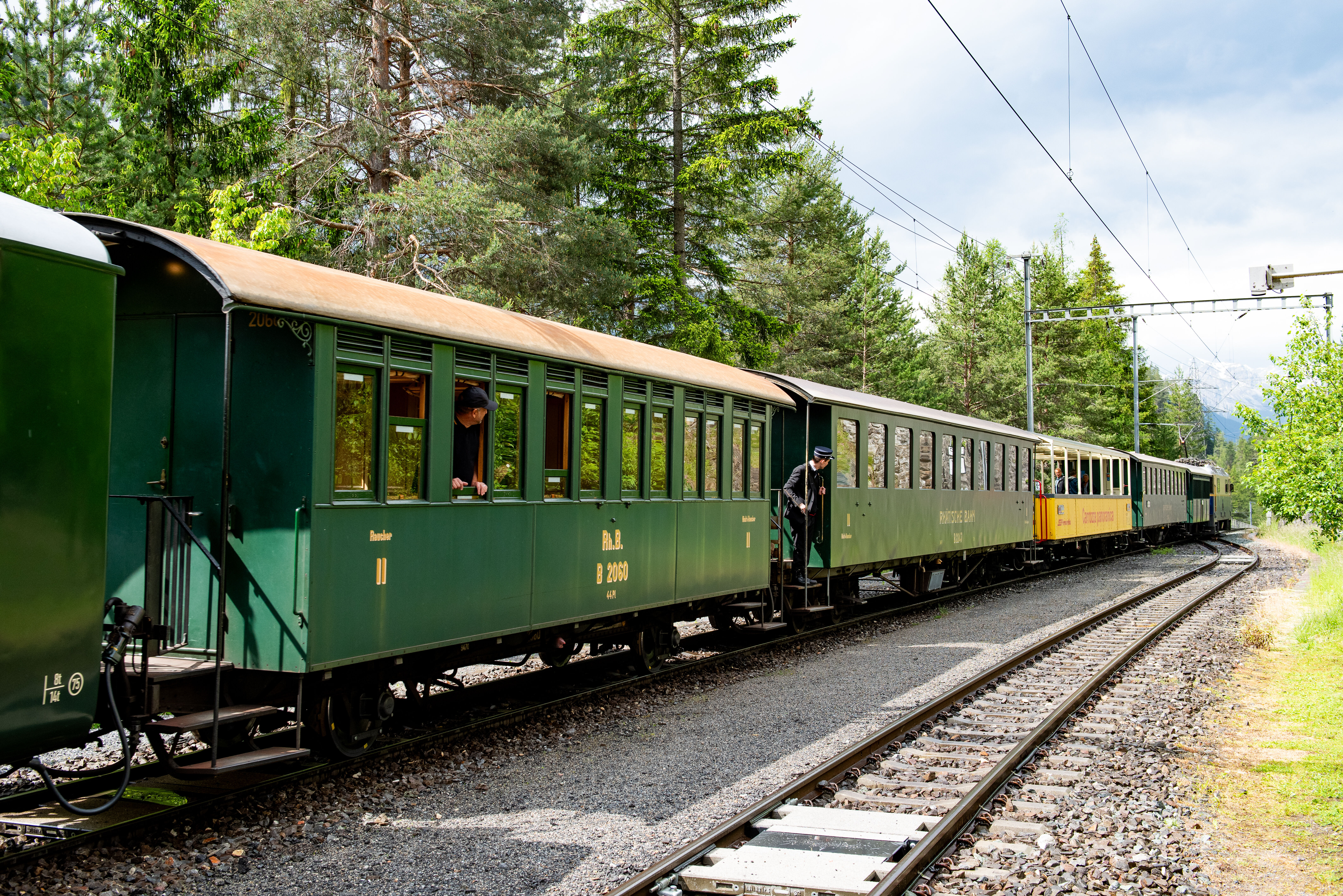 Die historischen Wagen der RhB und ein offener Aussichtwagen stehen bei Davos Wiesen. 