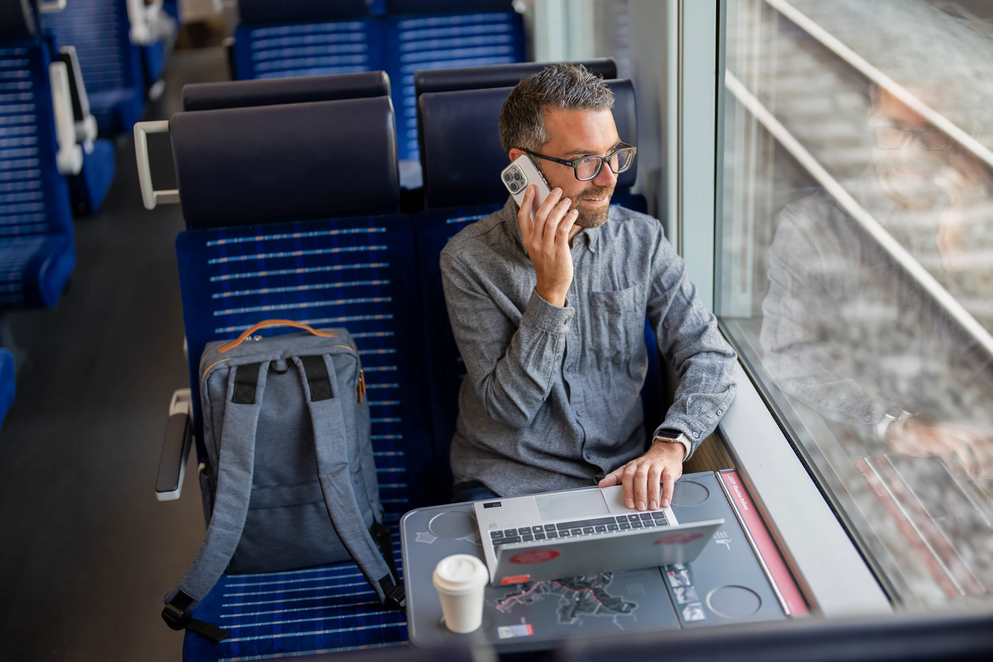 Mitarbeitender RhB telefoniert im Zug mit Mobiltelefon