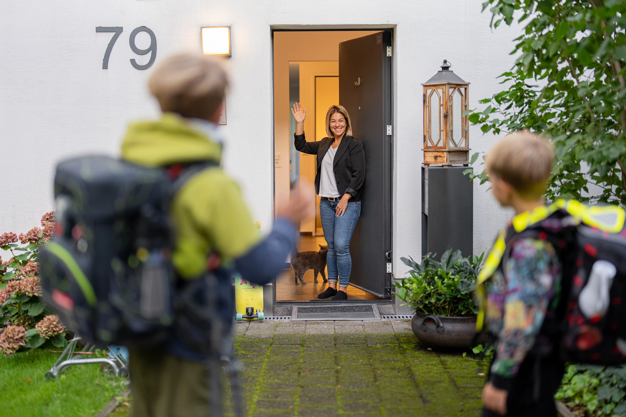 Eine Mutter verabschiedet ihre Kinder und geht ins Home Office