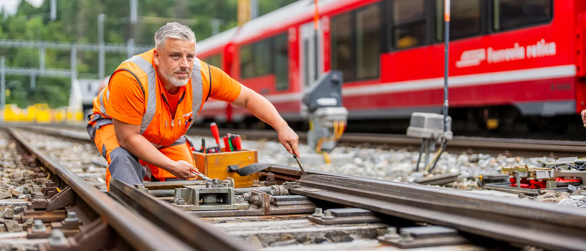 Ein Elektroinstallateur bei der Arbeit auf dem Gleis