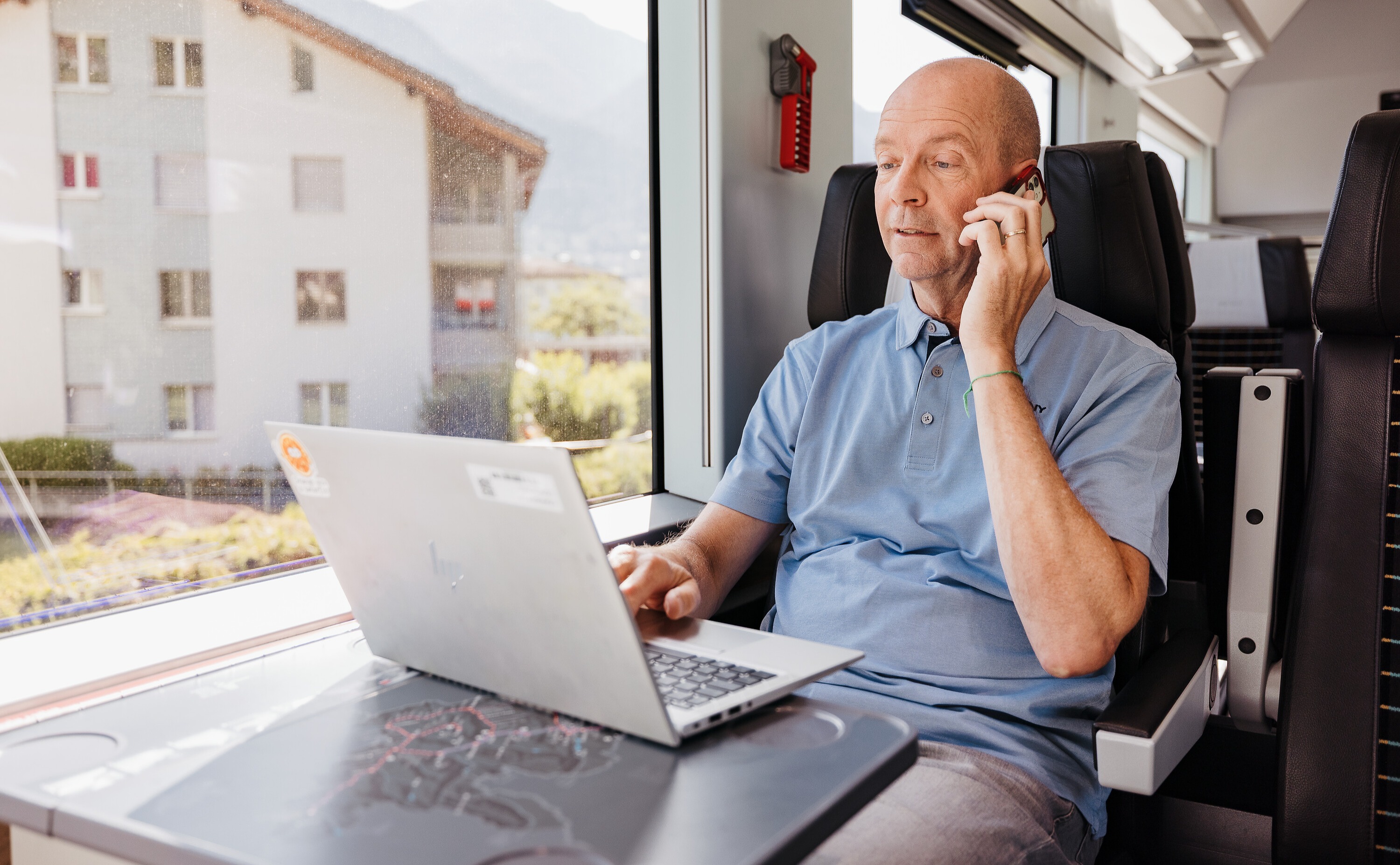 Mann in der 1. Klasse, mit Laptop und Smartphone