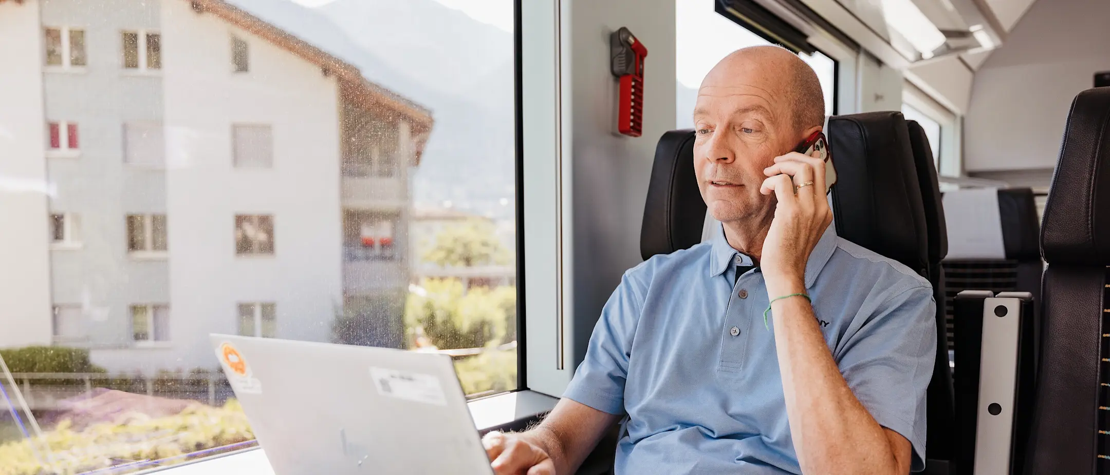 Mann in der 1. Klasse, mit Laptop und Smartphone