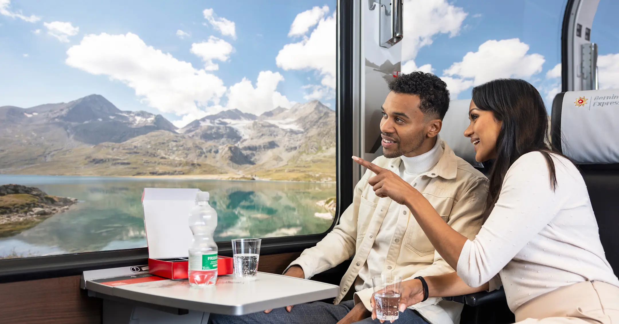 Fahrgäste im Bernina Express bestaunen den Lago Bianco auf dem Berninapass.