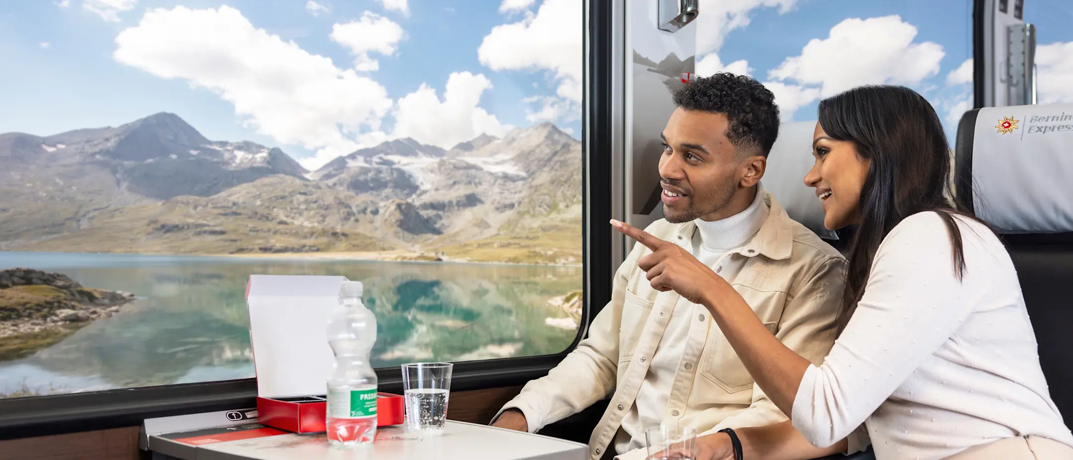 Fahrgäste im Bernina Express bestaunen den Lago Bianco auf dem Berninapass.