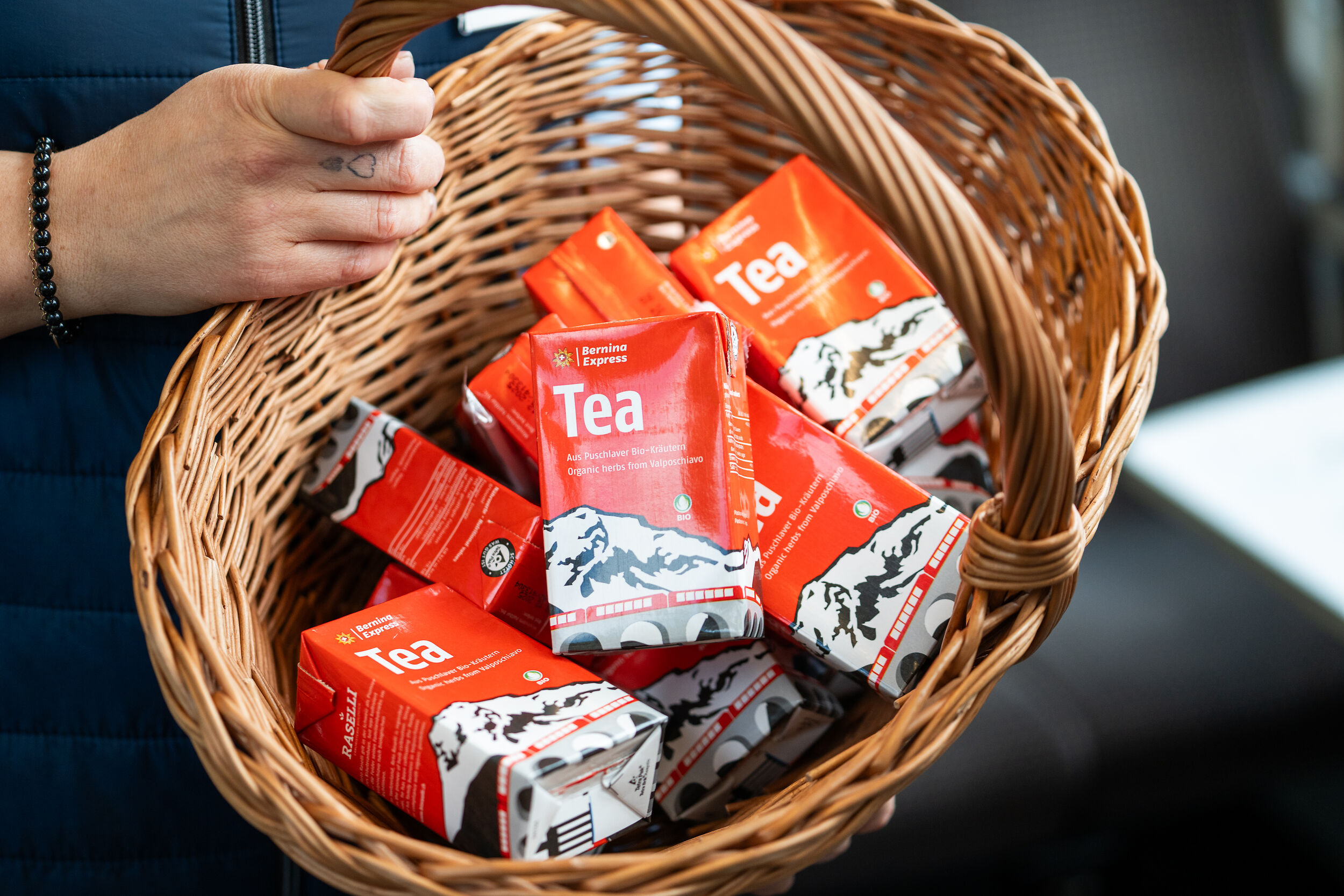 Der Bernina Express Eistee wird in einem Korb an die Gäste verteilt. 