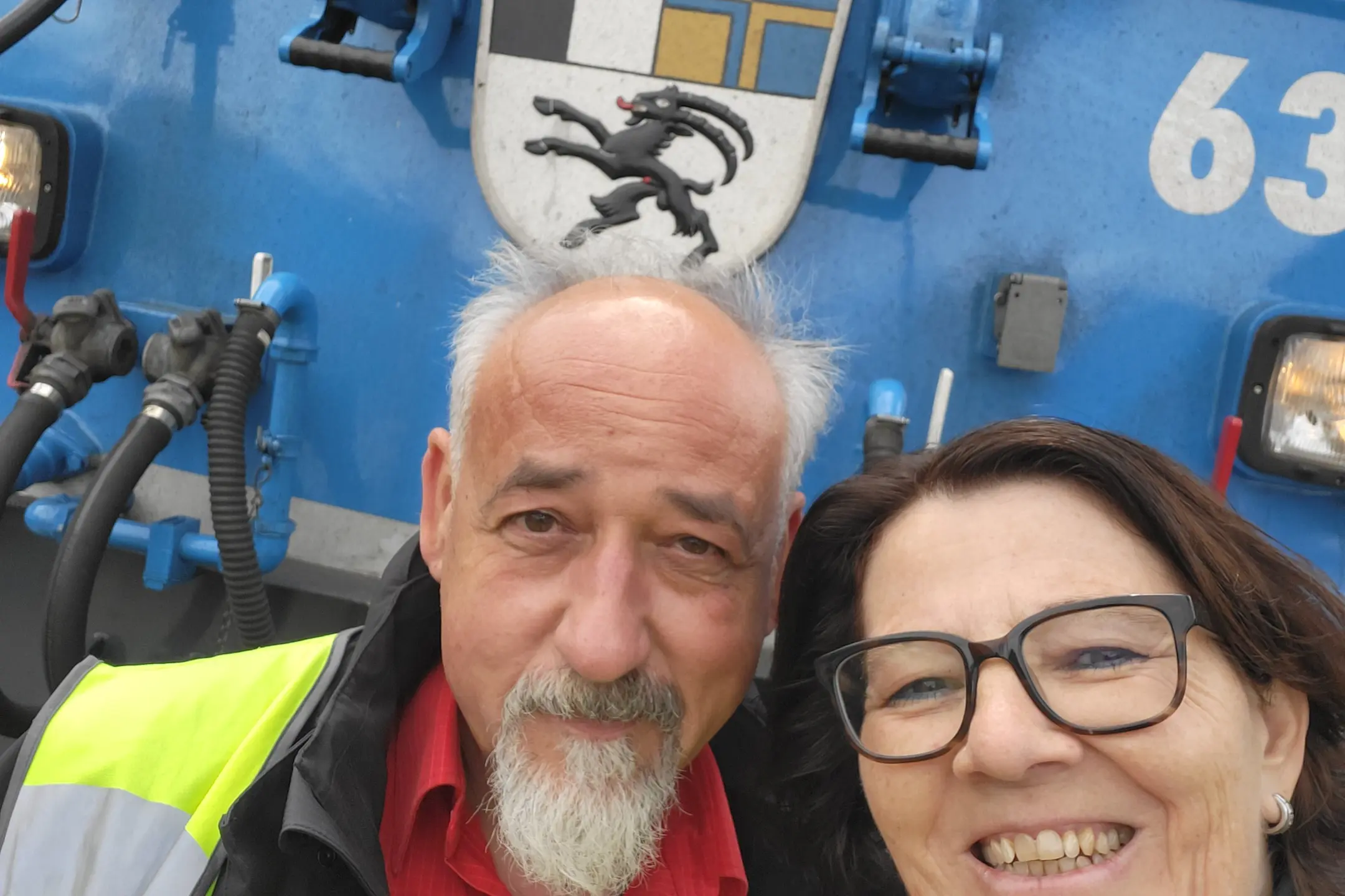 Zwei Mitarbeitende beim Austauschprogramm Visita vor einer Lokomotive