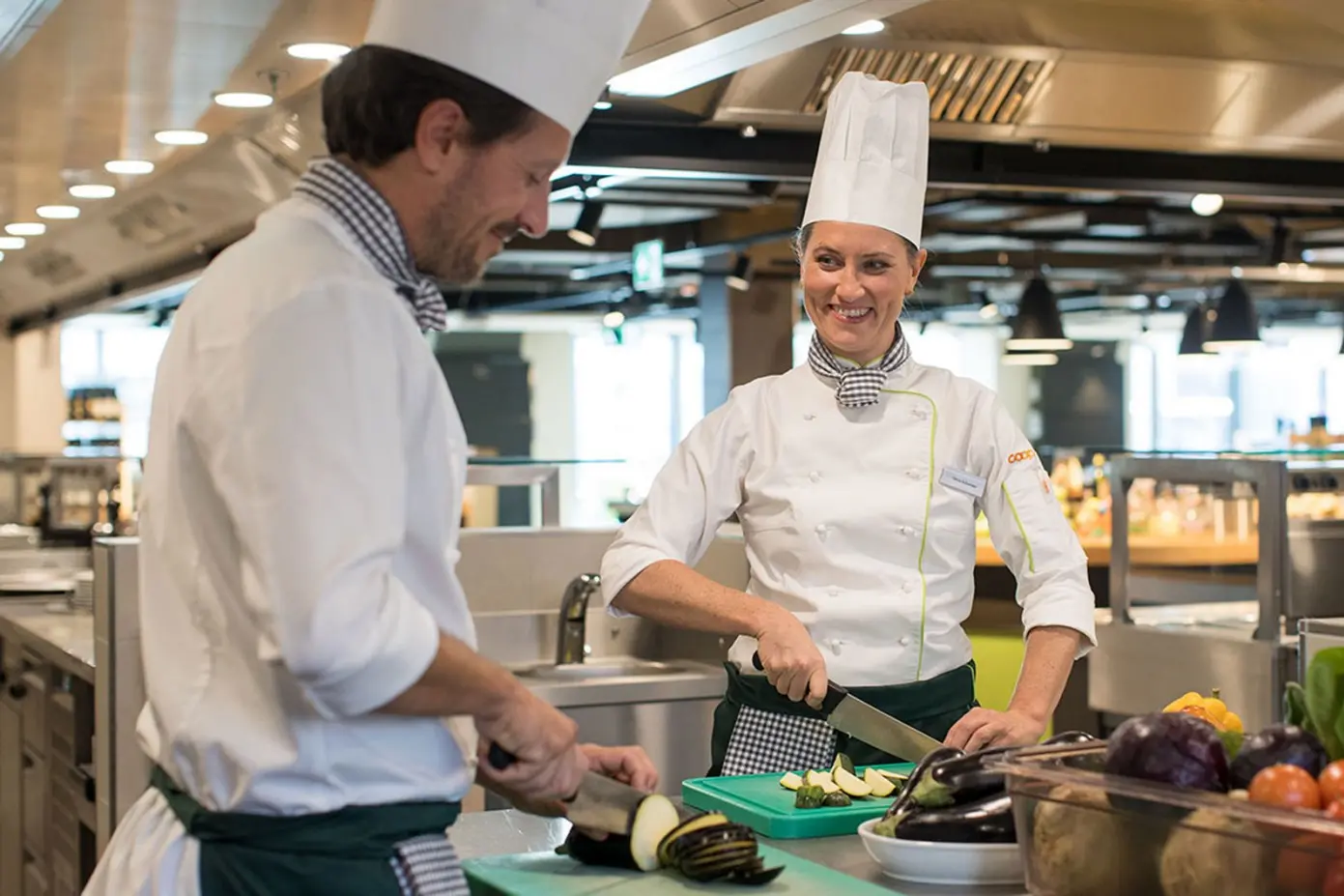 Zwei Köche am Gemüse zubereiten in einem Coop Restaurant