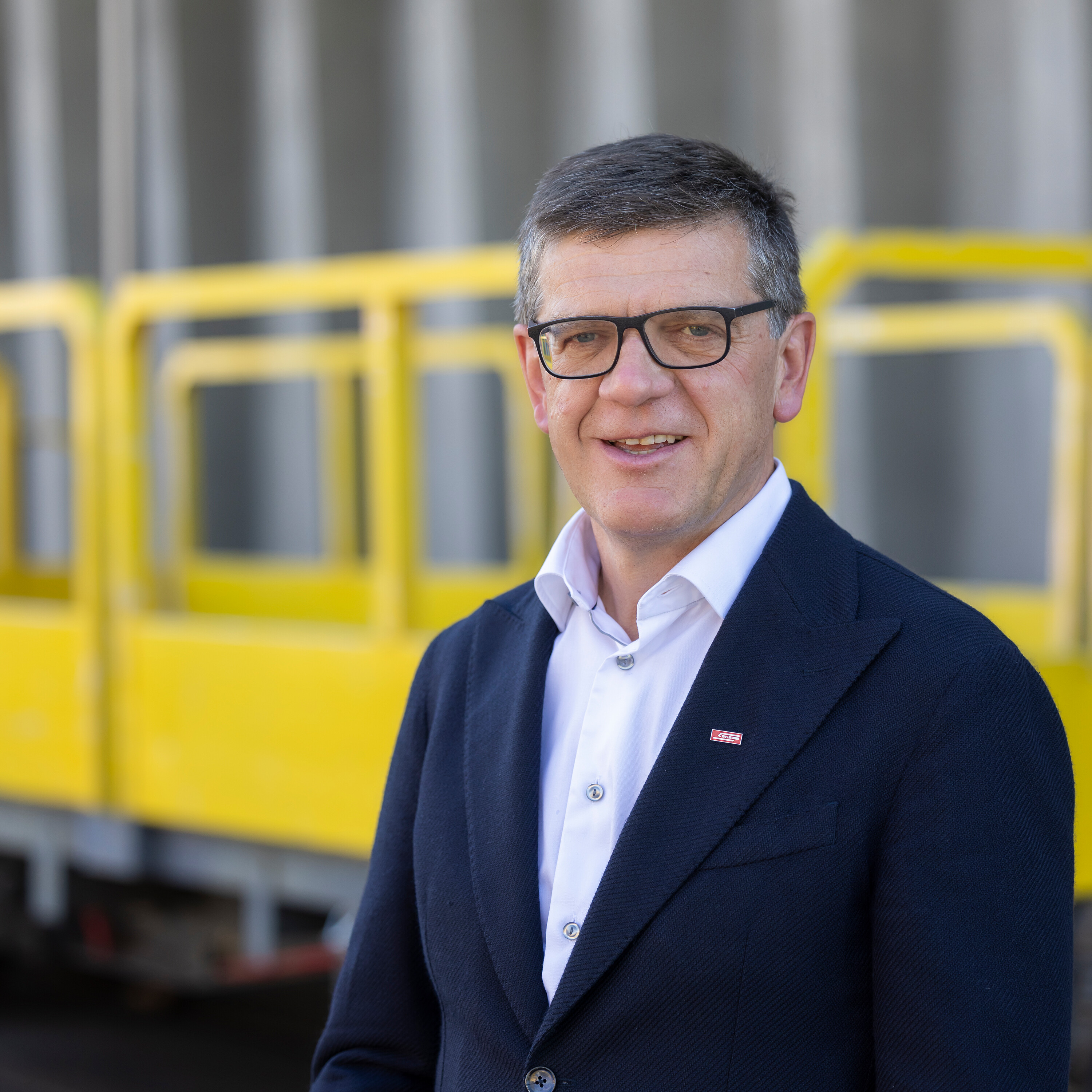 Kurt Baumgartner - Verwaltungsrat vor gelbem Güterwagen