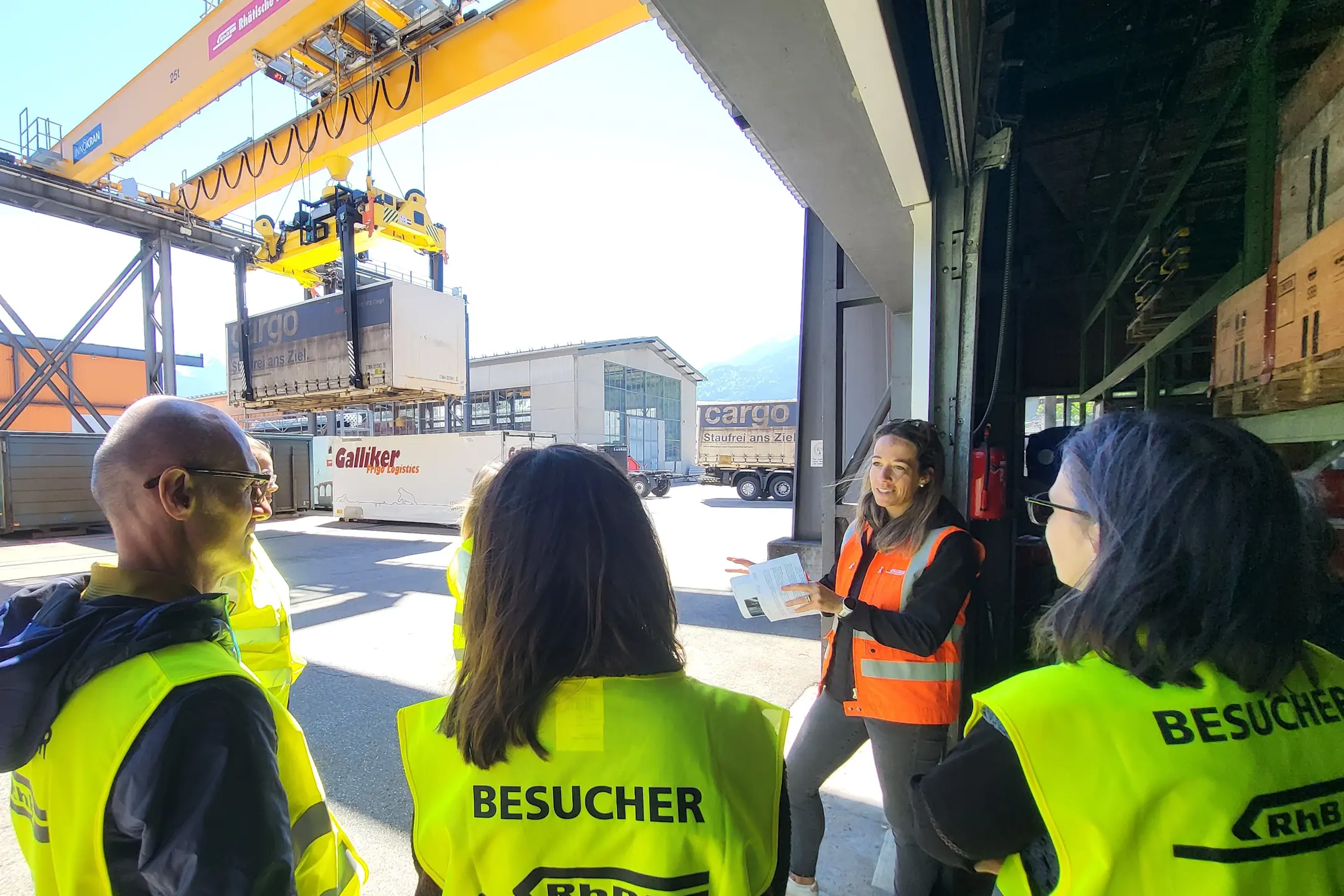 Eine Mitarbeiterin erklärt den Güterverkehr-Bereich - eine Gruppe hört zu
