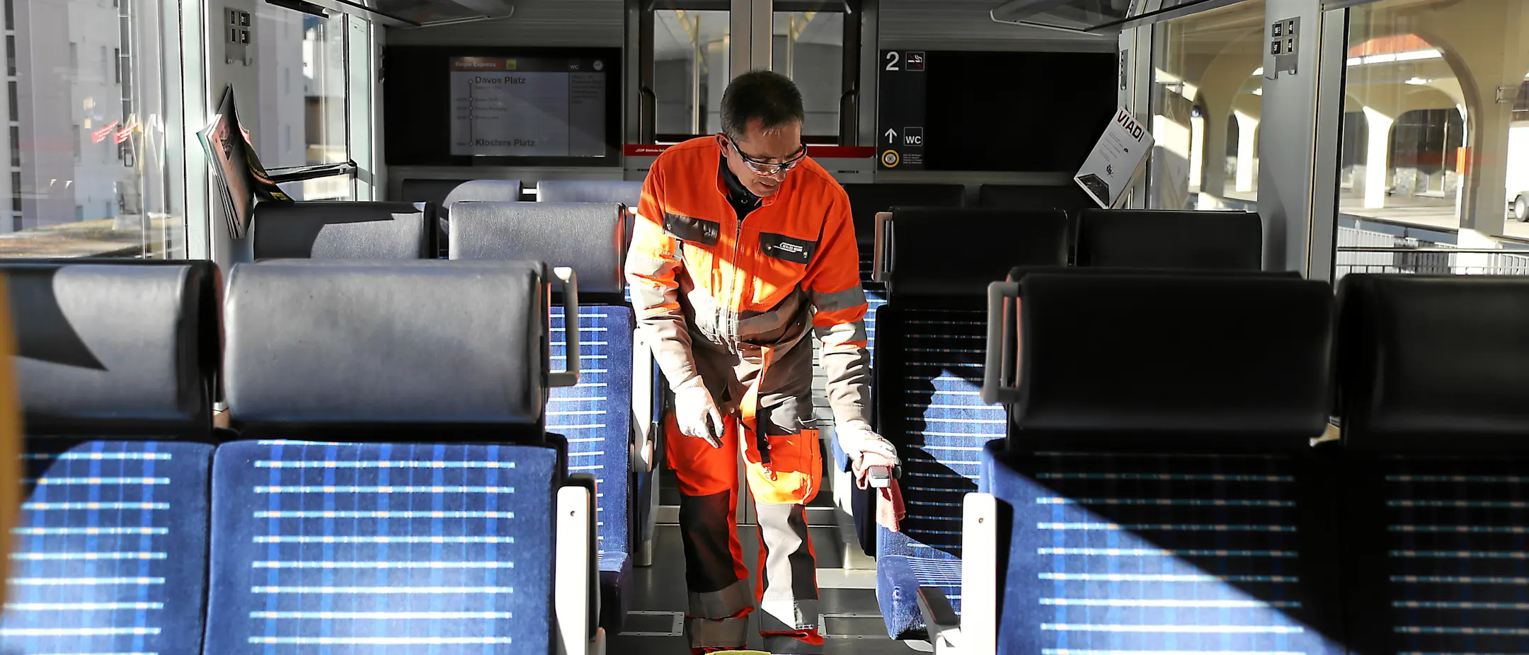 Wagenreiniger im Innern eines RhB Zuges