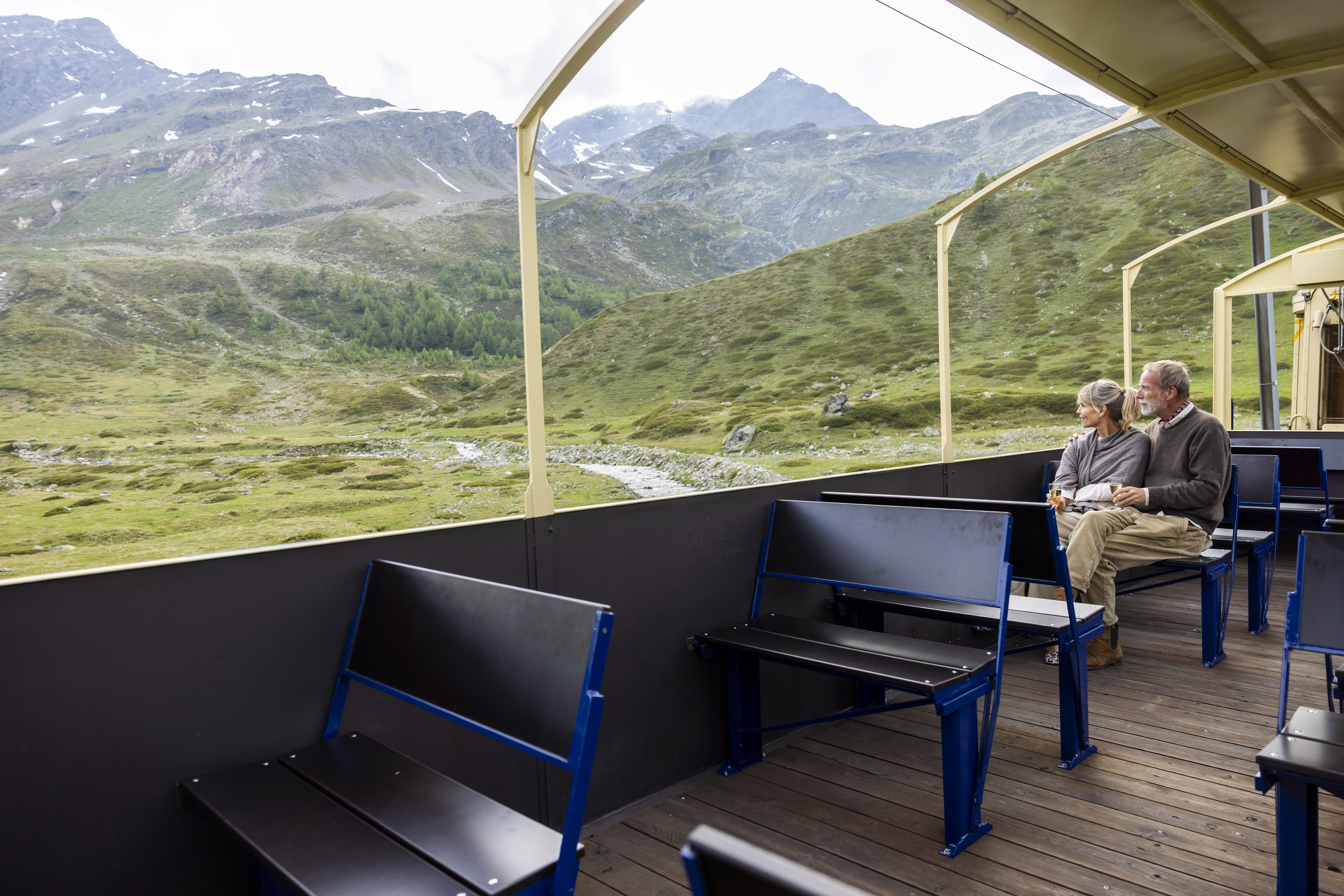 Cabrio Feeling: Ein Pärchen sitzt im offenen Aussichtswagen der Bernina Express Pullman Class.