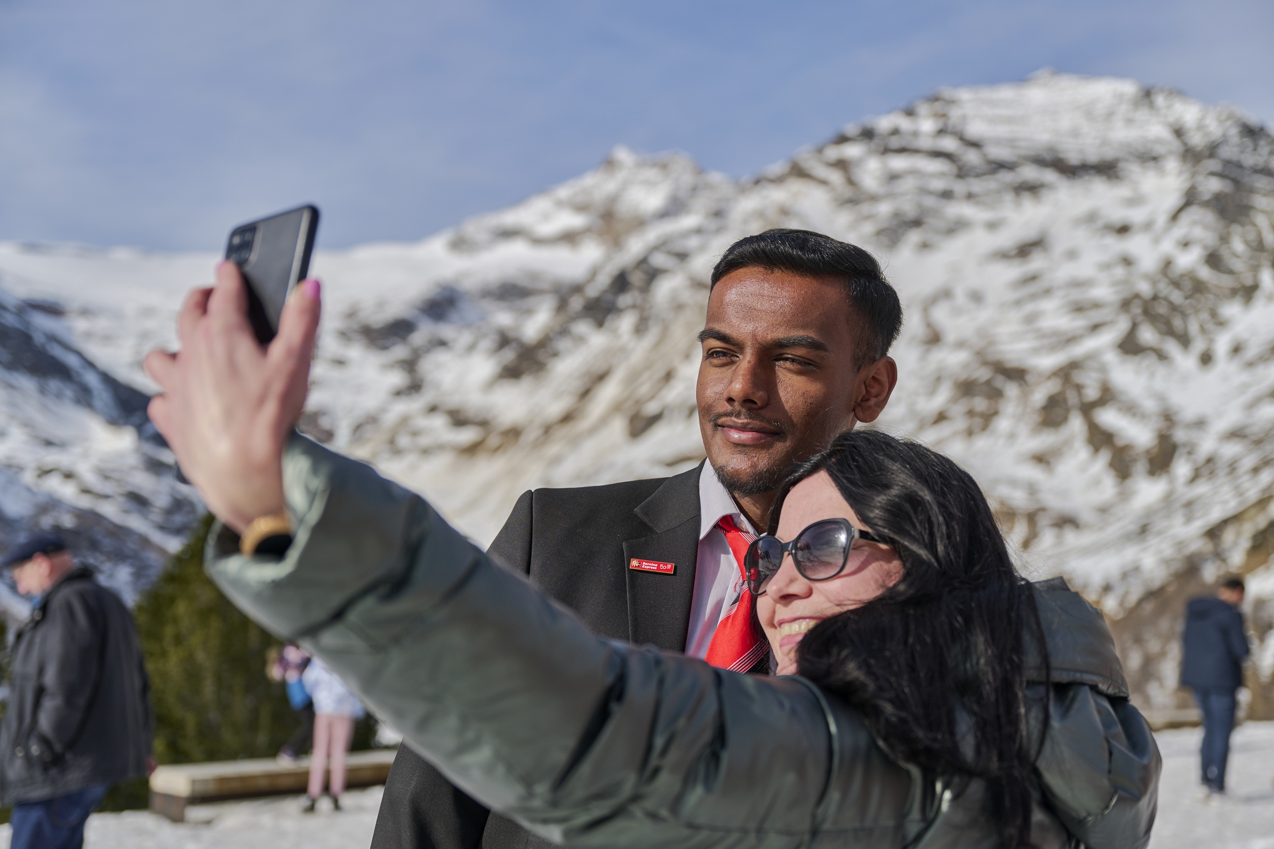 Ein Zugbegleiter der RhB macht ein Selfie mit einer Touristin. 