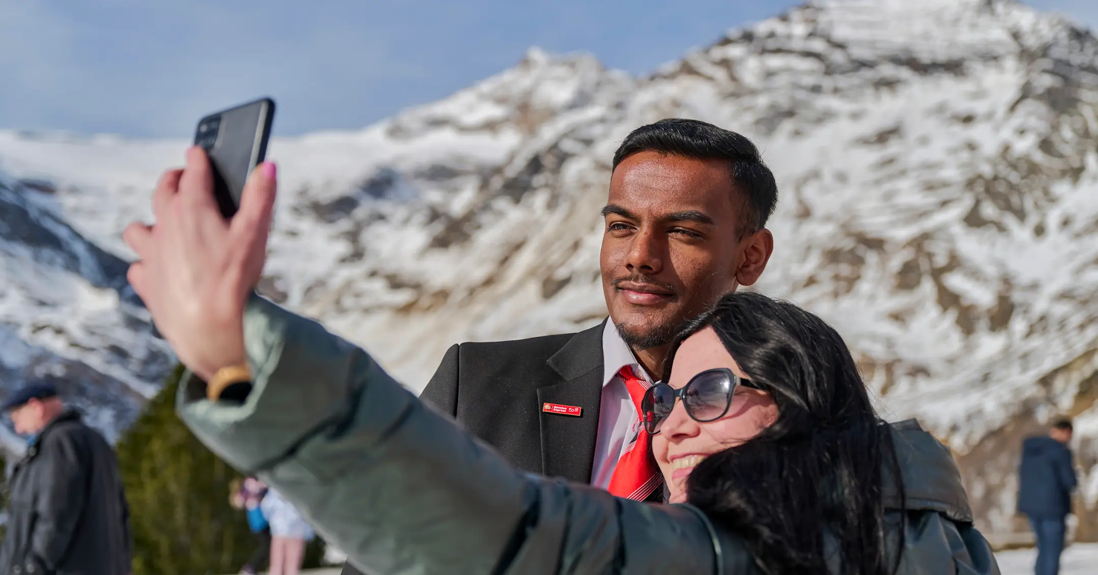 Ein Zugbegleiter der RhB macht ein Selfie mit einer Touristin.