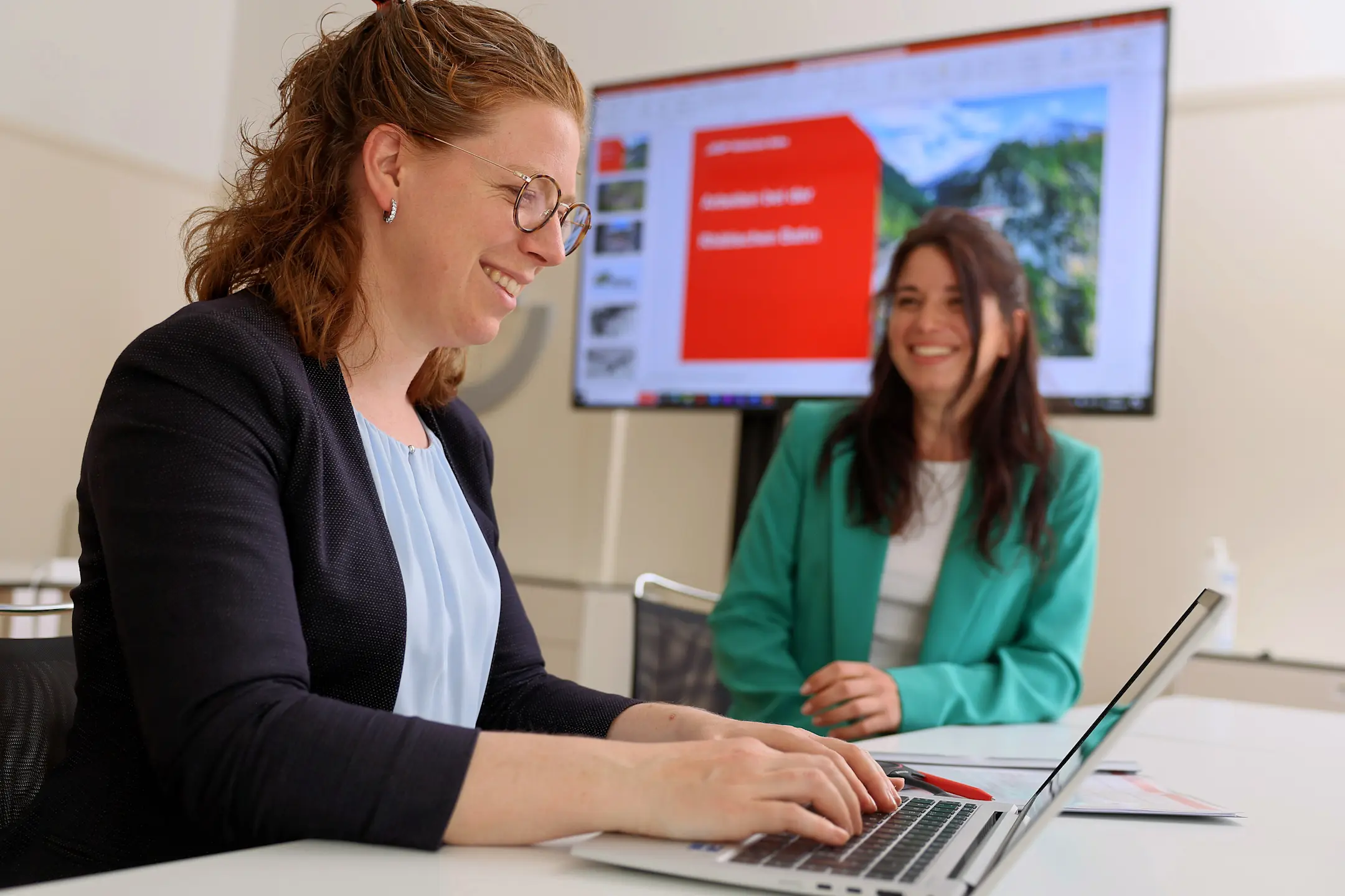 Zwei Mitarbeitende der RhB unterhalten sich im Büro.