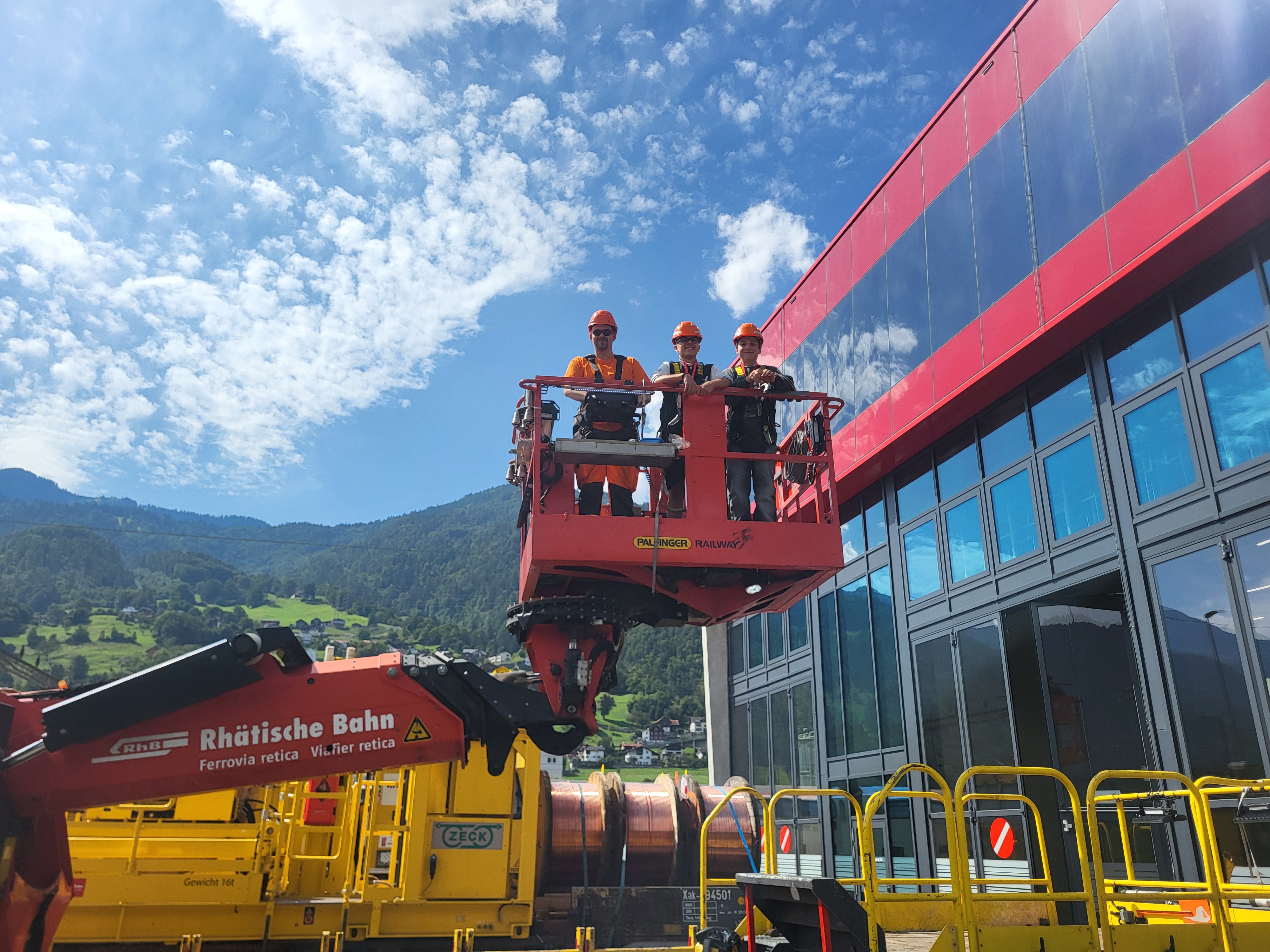 Zwei Jugendliche und ein Ausbildner am Berufswahltag RhB auf einer Hebebühne
