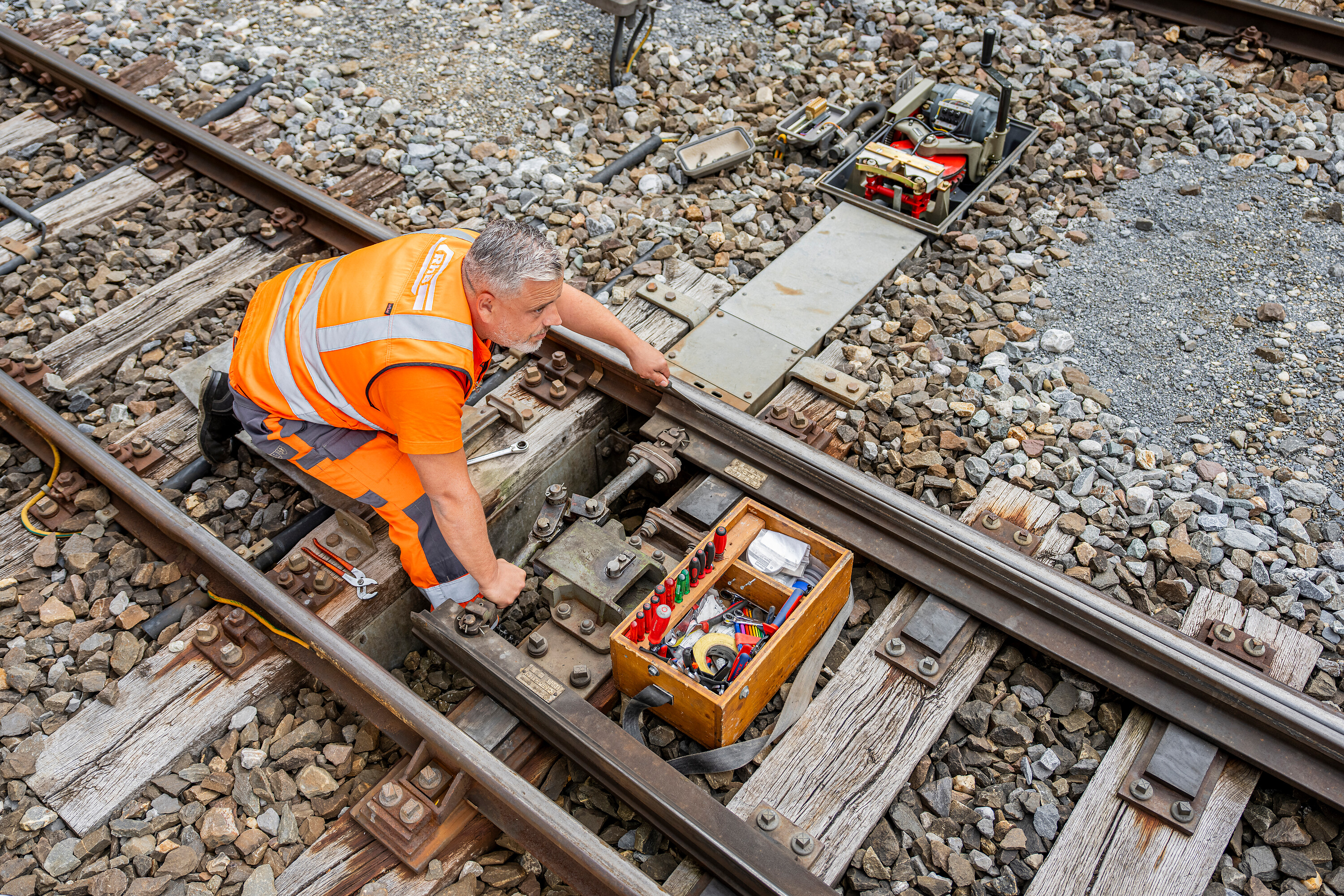 An electrician at work on the track bed.