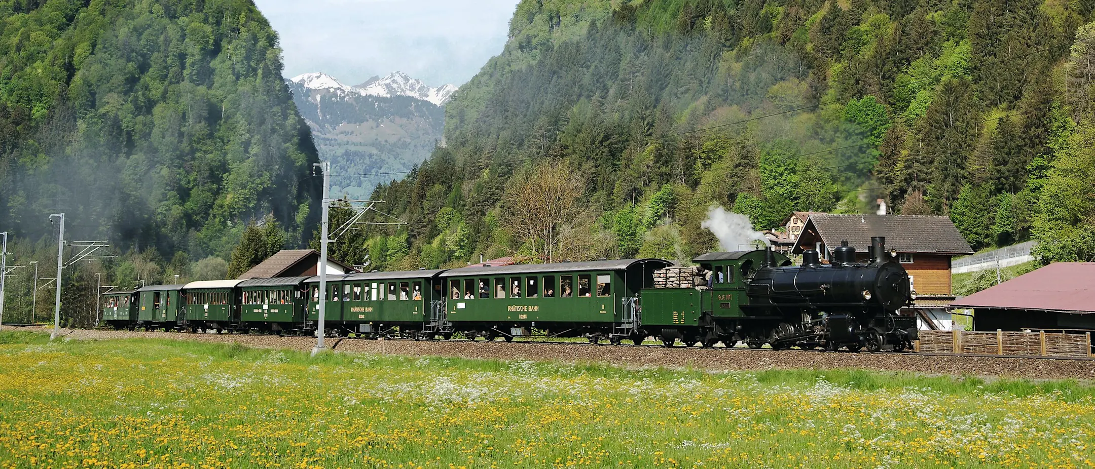 Uno storico treno a vapore attraversa il paesaggio primaverile nei pressi di Seewis in Prettigovia.