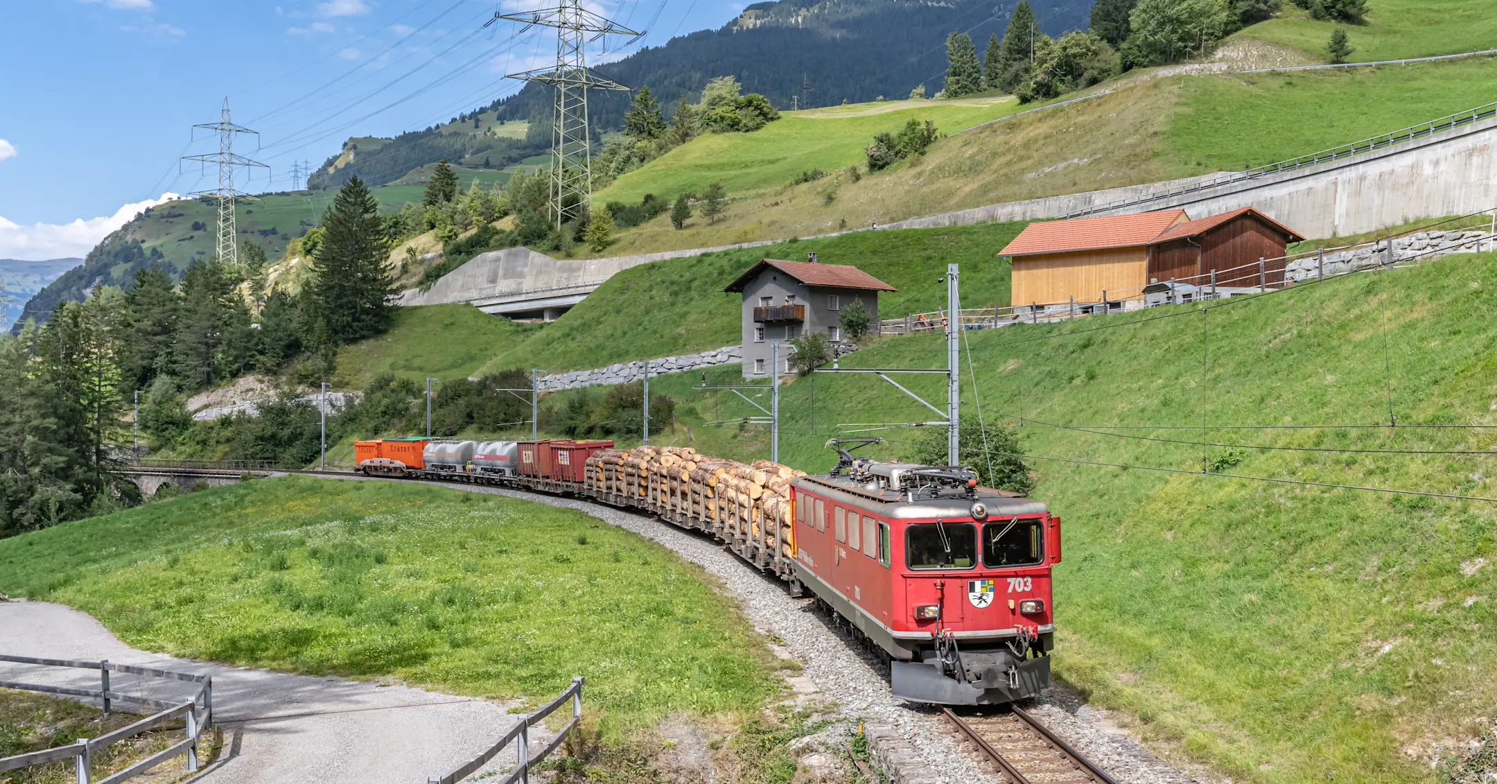 Ein Güterzug der Rhätischen Bahn fährt im Sommer durch das Albulatal für den Gütertransport in Graubünden