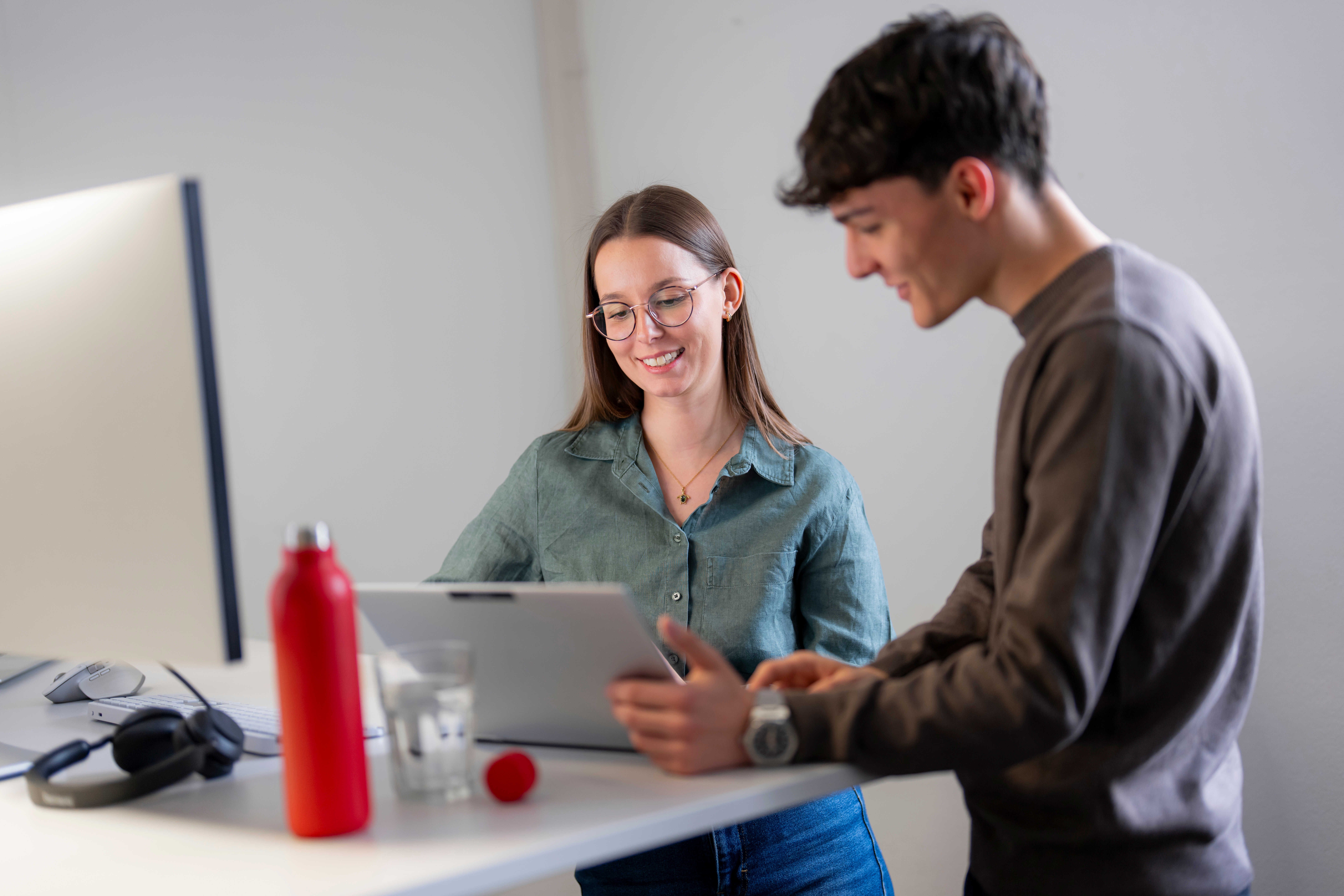 IT employee with laptop at a meeting and a red bottle