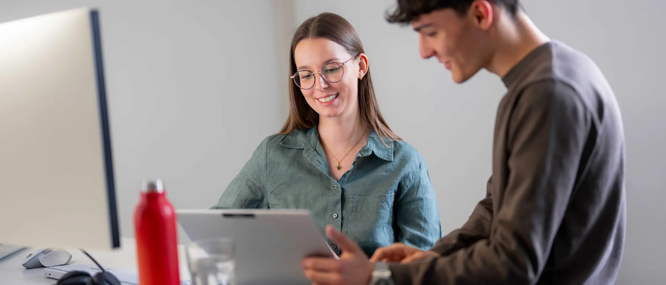 IT employee with laptop at a meeting and a red bottle