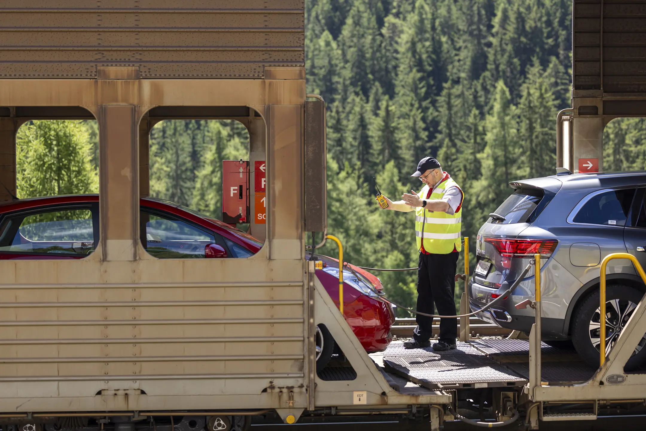 Mitarbeiter der Rhätischen Bahn kontrolliert Fahrzeuge auf dem Autoverladezug im Vereinatunnel.