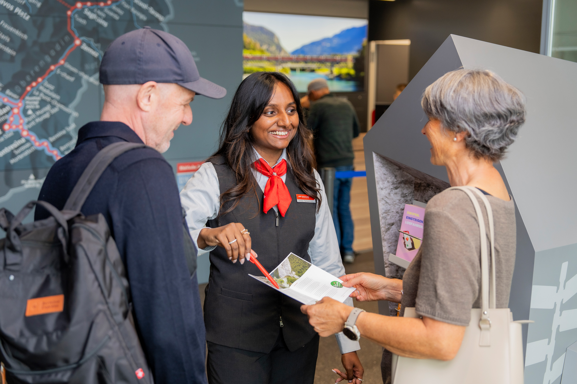 RhB Reiseberaterin berät am Schalter ein Ehepaar