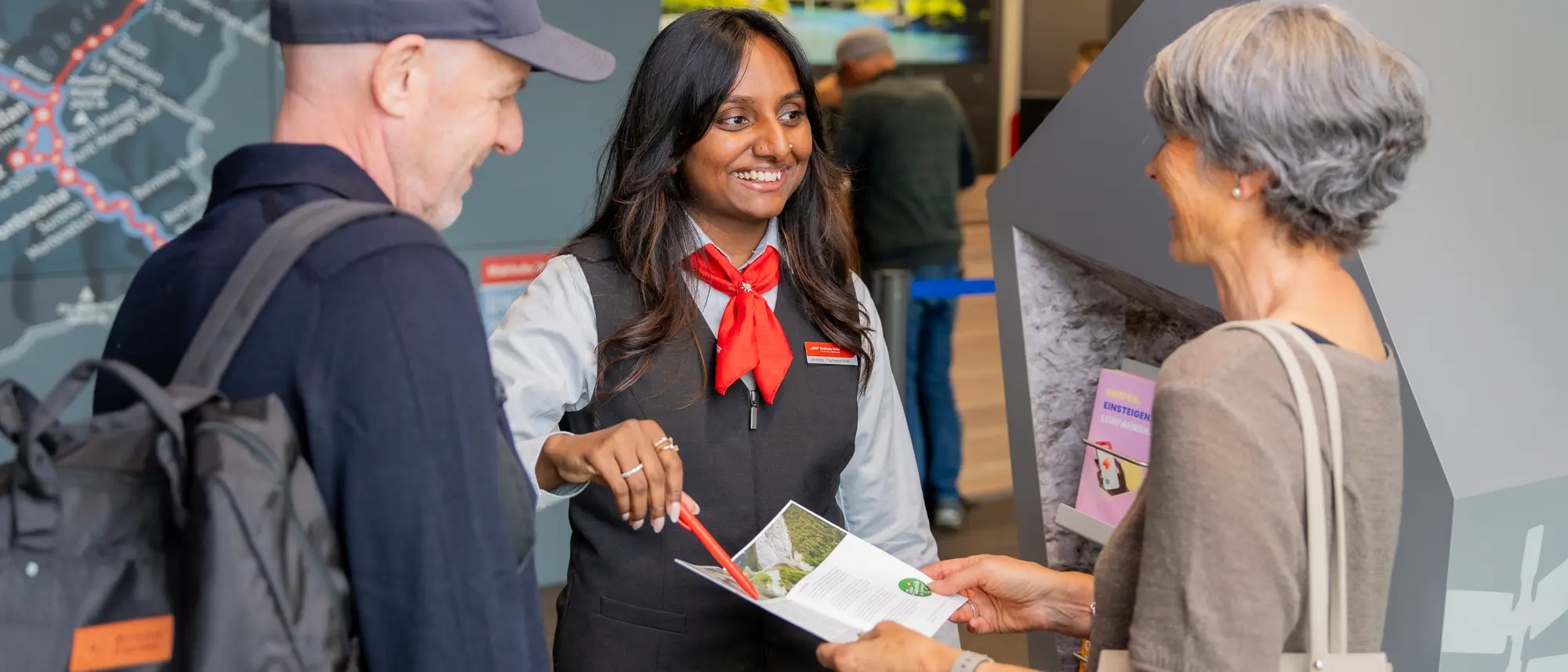 RhB Reiseberaterin berät am Schalter ein Ehepaar