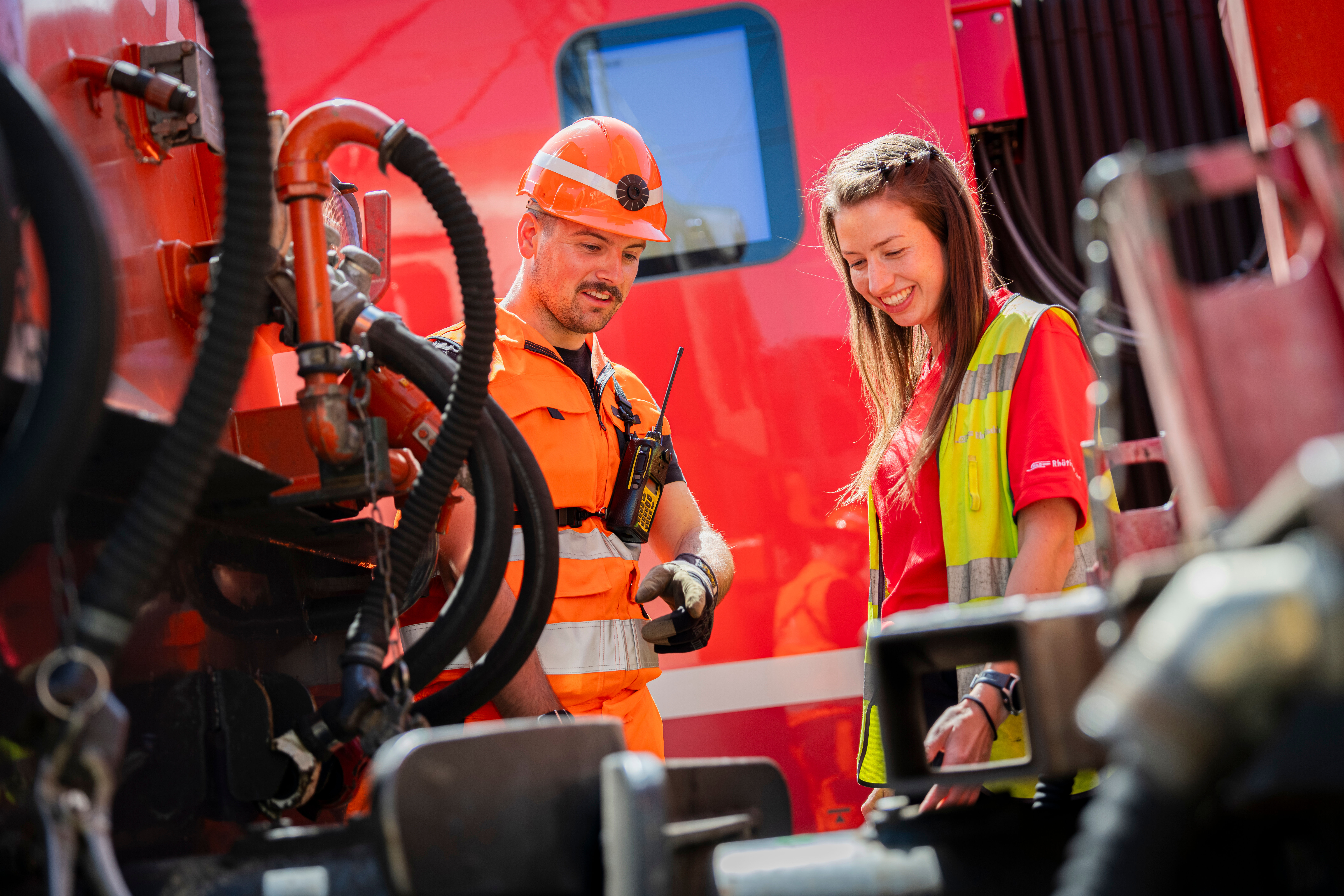 Rangiermitarbeiter und Lokführerin im Gespräch bei einer Lokomotive