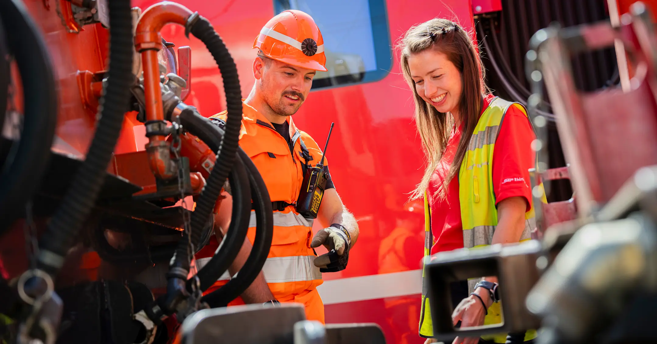 Rangiermitarbeiter und Lokführerin im Gespräch bei einer Lokomotive