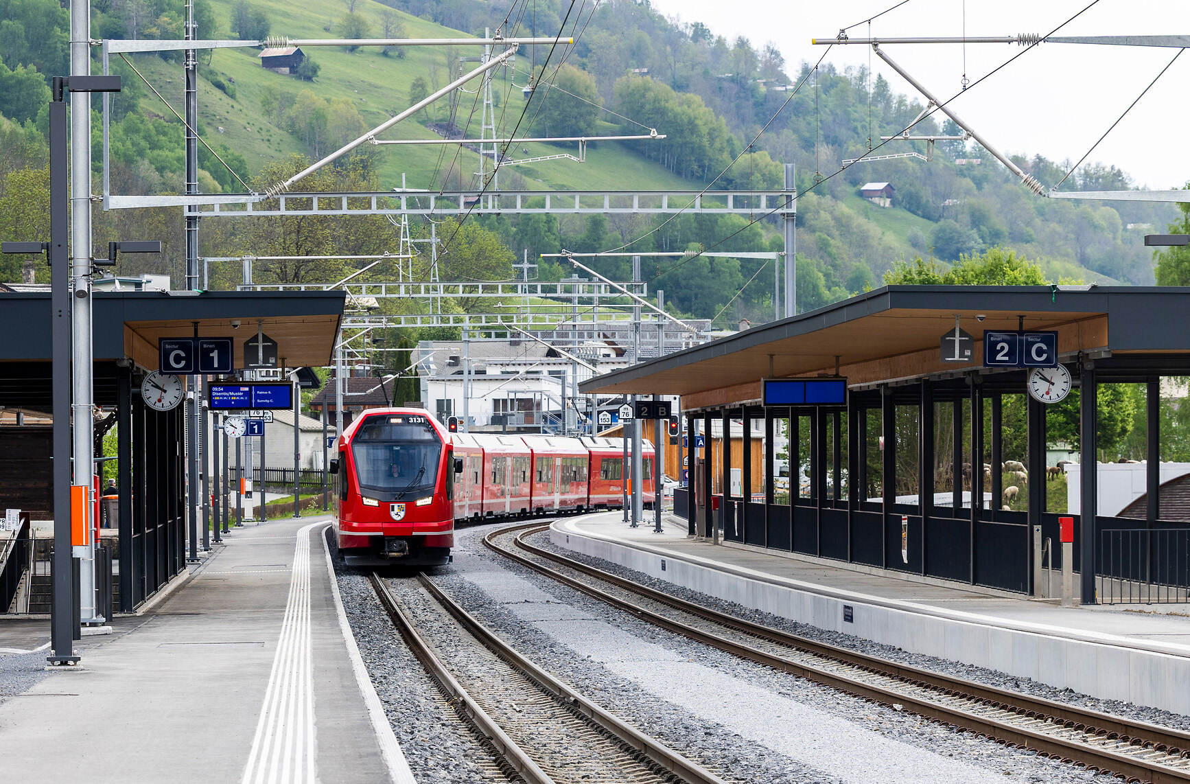 Zwei gekuppelte Capricorn-Triebzüge fahren durch den Bahnhof Trun.