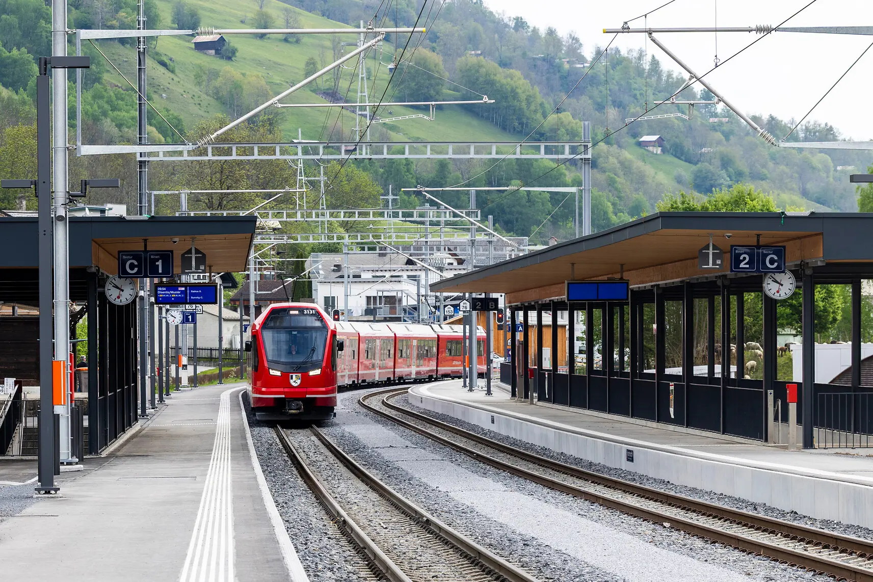 Zwei gekuppelte Capricorn-Triebzüge fahren durch den Bahnhof Trun.
