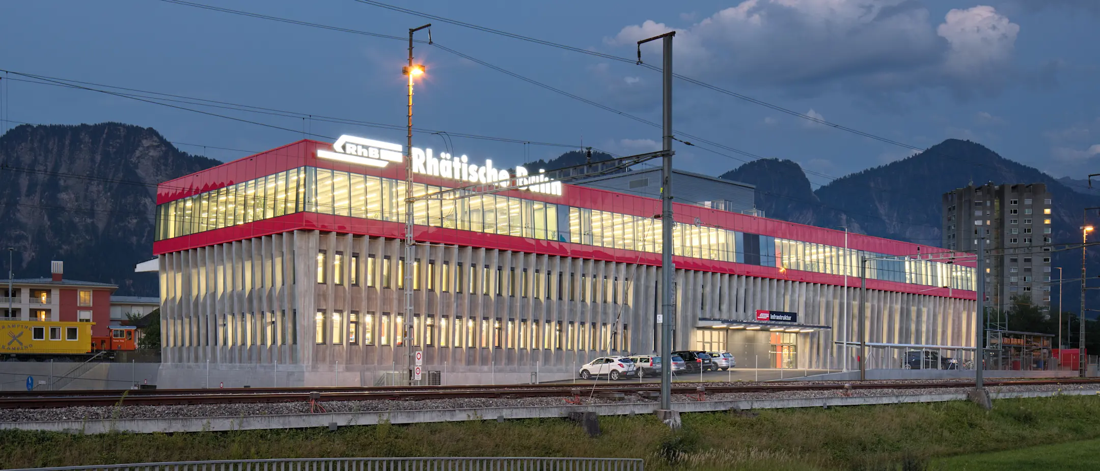 Der Infrastrukturstützpunkt der Rhätischen Bahn am Bahnhof Landquart, beleuchtet bei Nacht
