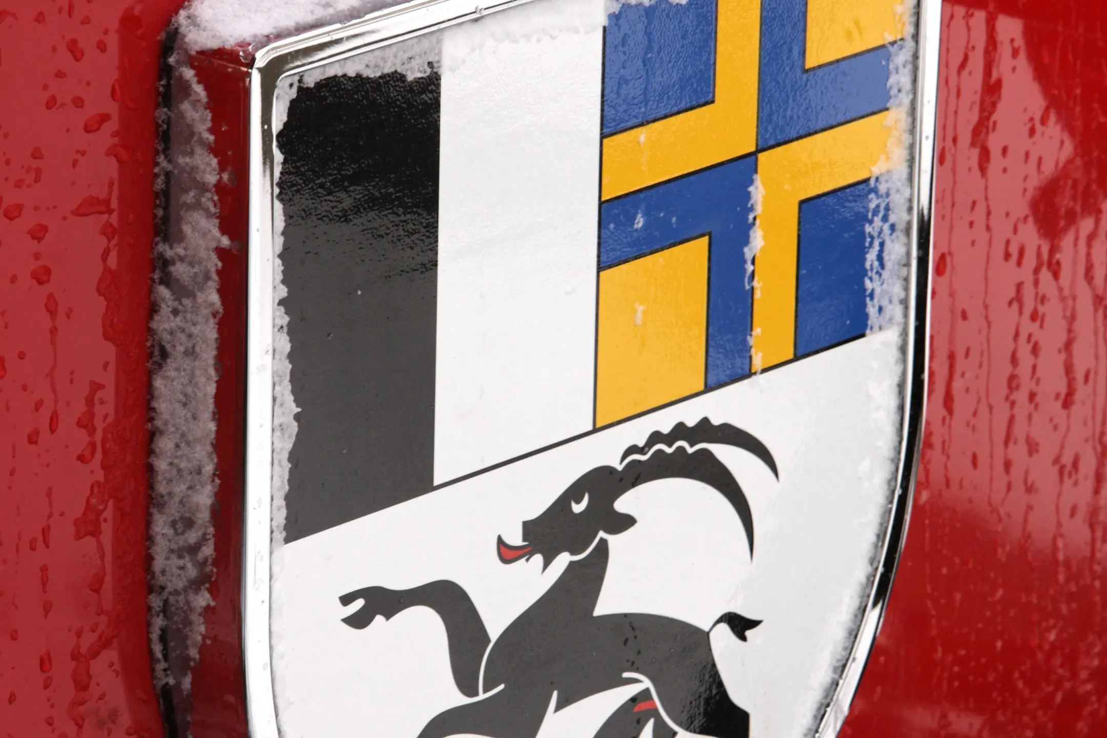 Wappen des Kantons Graubünden an der Front eines roten RhB-Zuges, mit Eiszapfen bedeckt.