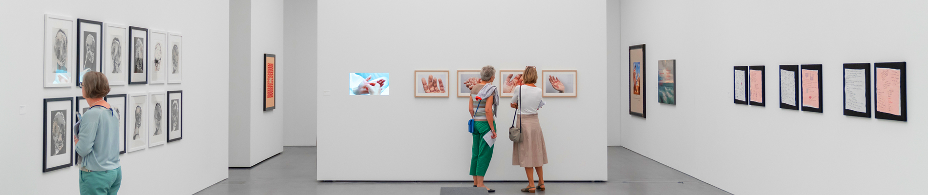 Zwei Personen schauen sich Bilder im Bündner Kunstmuseum an.