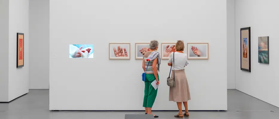 Zwei Personen schauen sich Bilder im Bündner Kunstmuseum an.