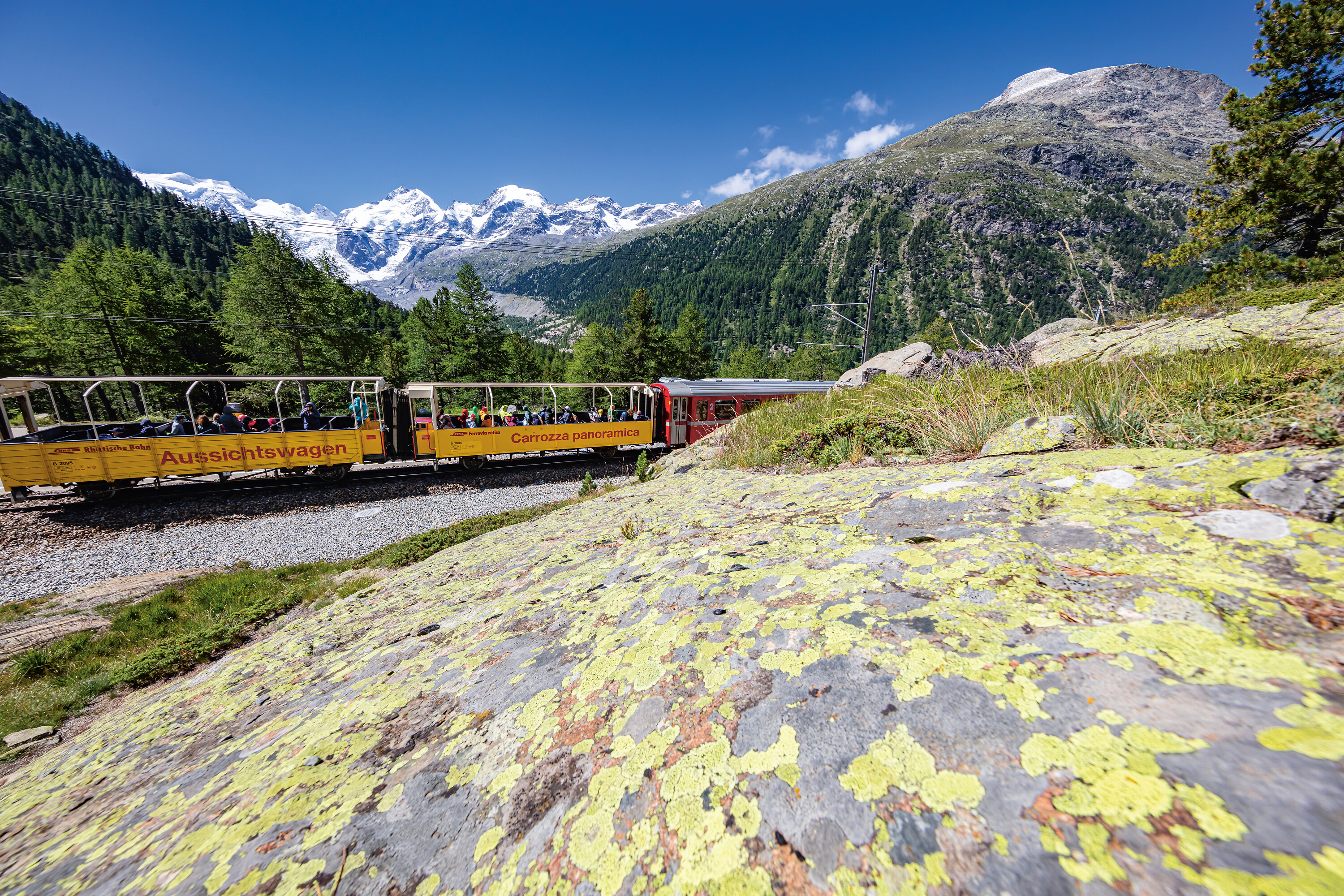 Regionalzug mit zwei offenen Aussichtswagen mit dem Morteratschgletscher im Hintergrund.