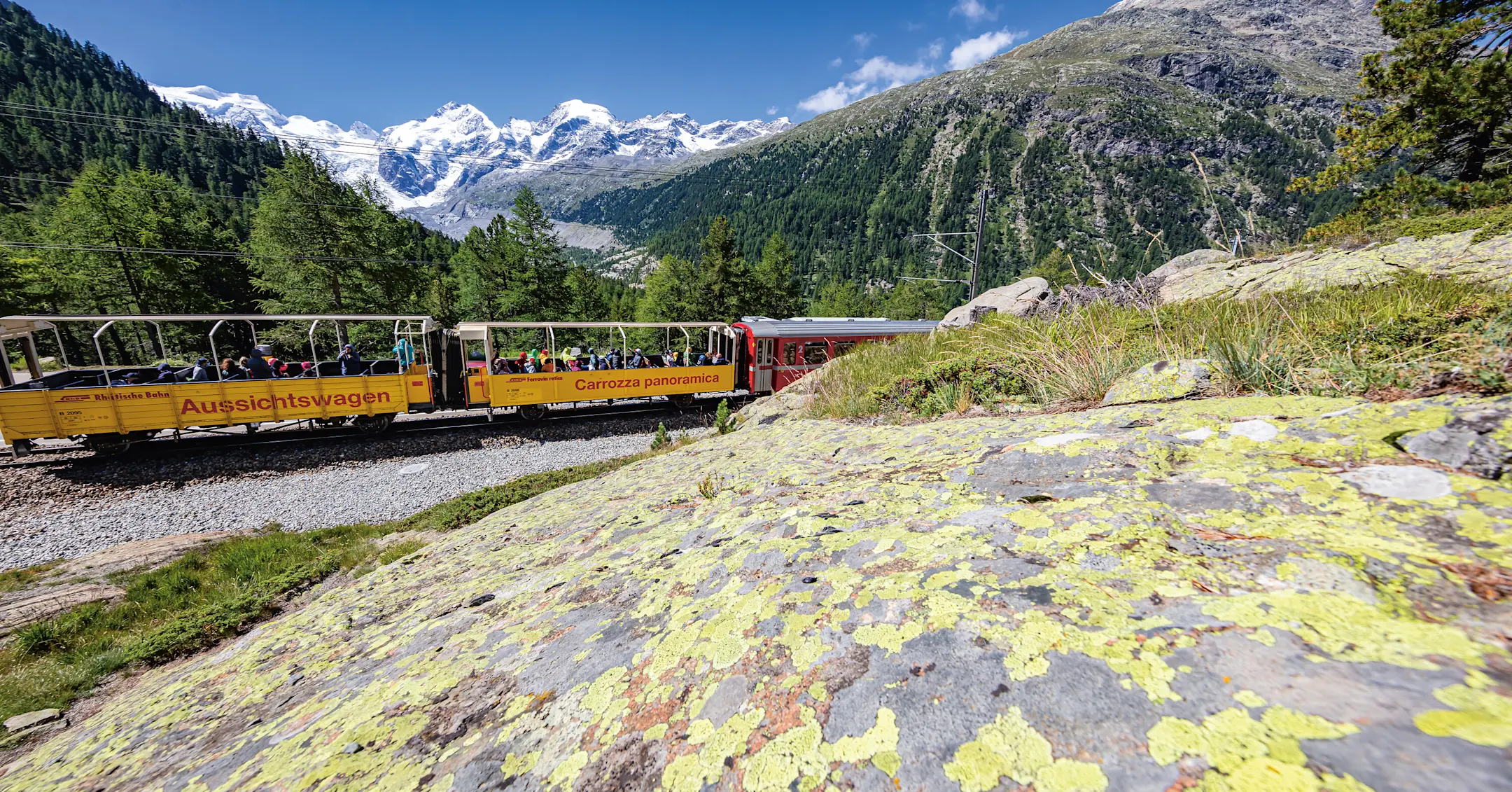 Regionalzug mit zwei offenen Aussichtswagen mit dem Morteratschgletscher im Hintergrund.