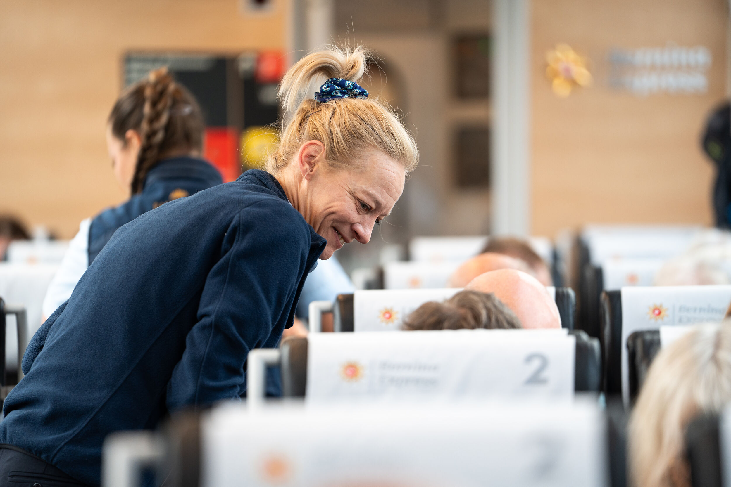 Eine Mitarbeiterin berät auf dem Bernina Express Gäste. 